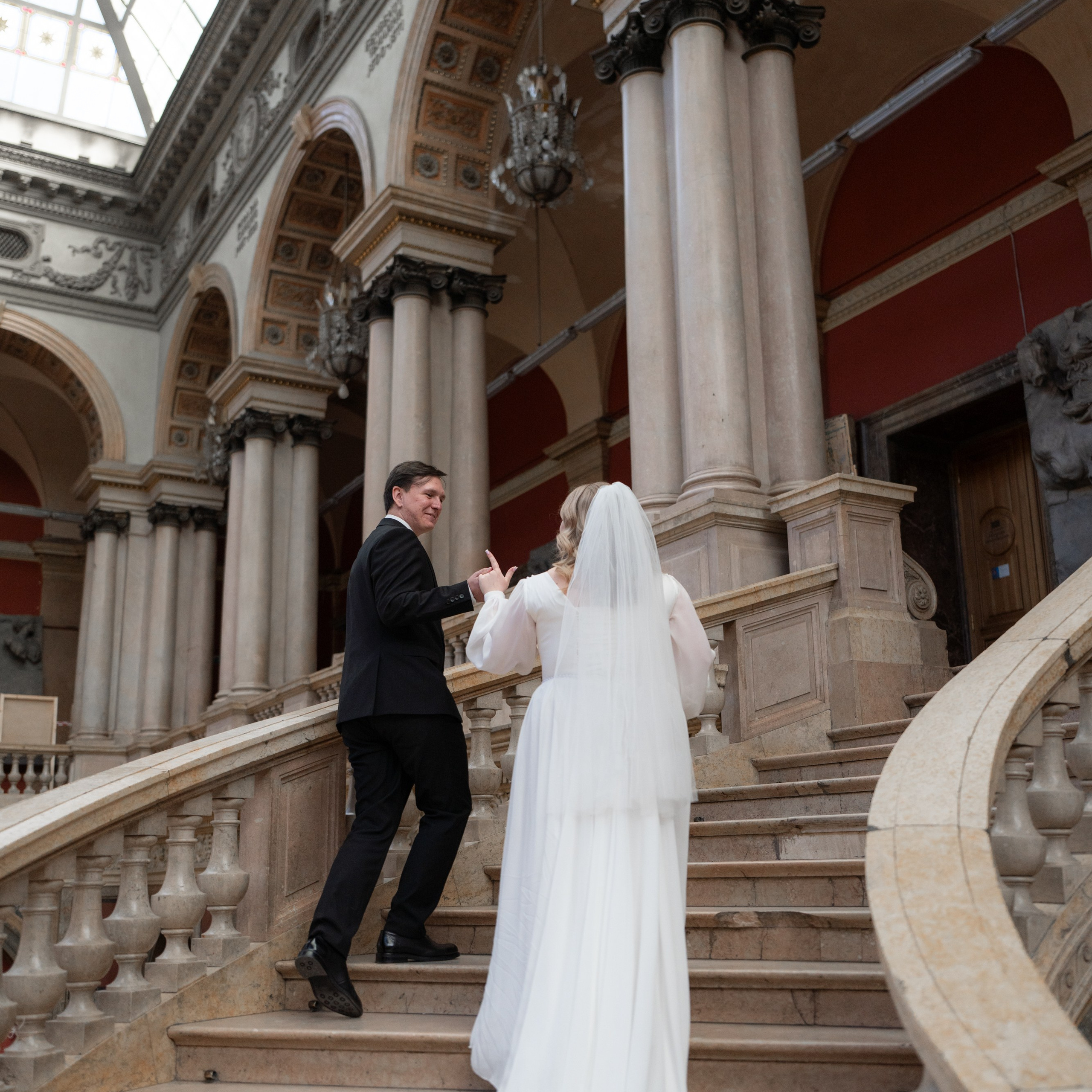 Свадебная фотосессия в академии Штиглица в Санкт-Петербурге невеста и жених поднимаются по центральной лестнице