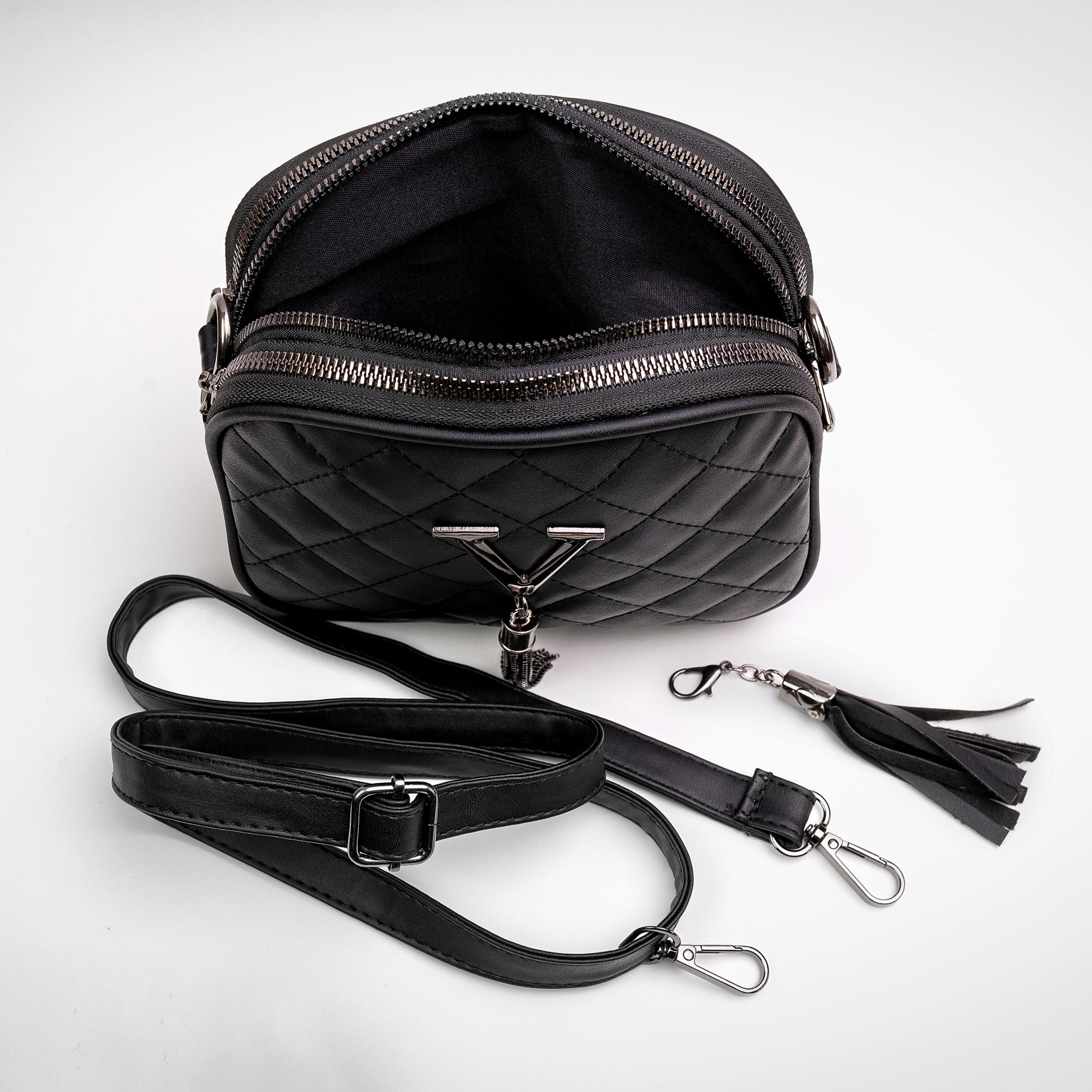 Чёрная кожаная сумка на белом фоне с расстёгнутой молнией и раскрыта