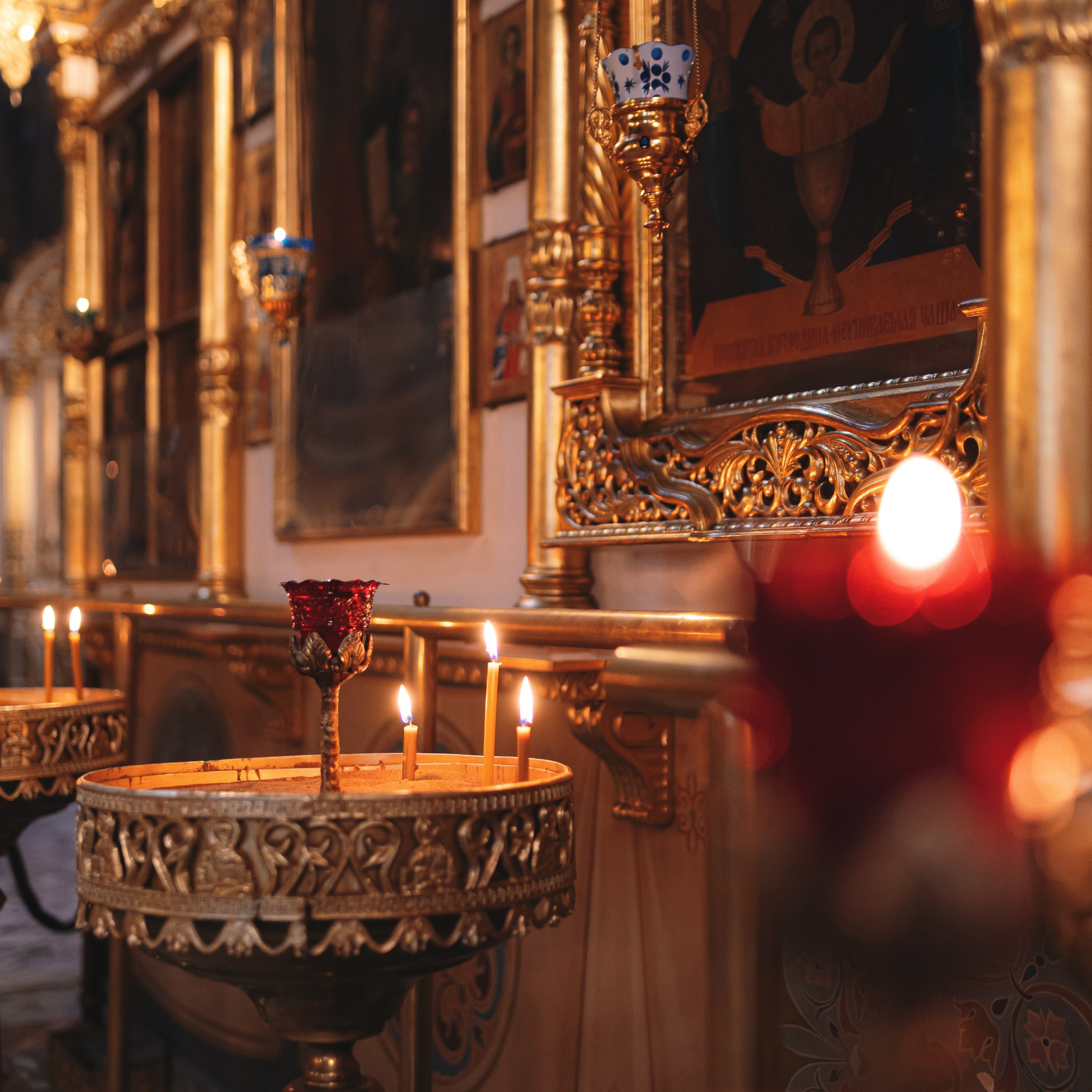 Деталь Таинства Крещения — горящие свечи и иконы. Фото передаёт особый уют и торжественность обряда.