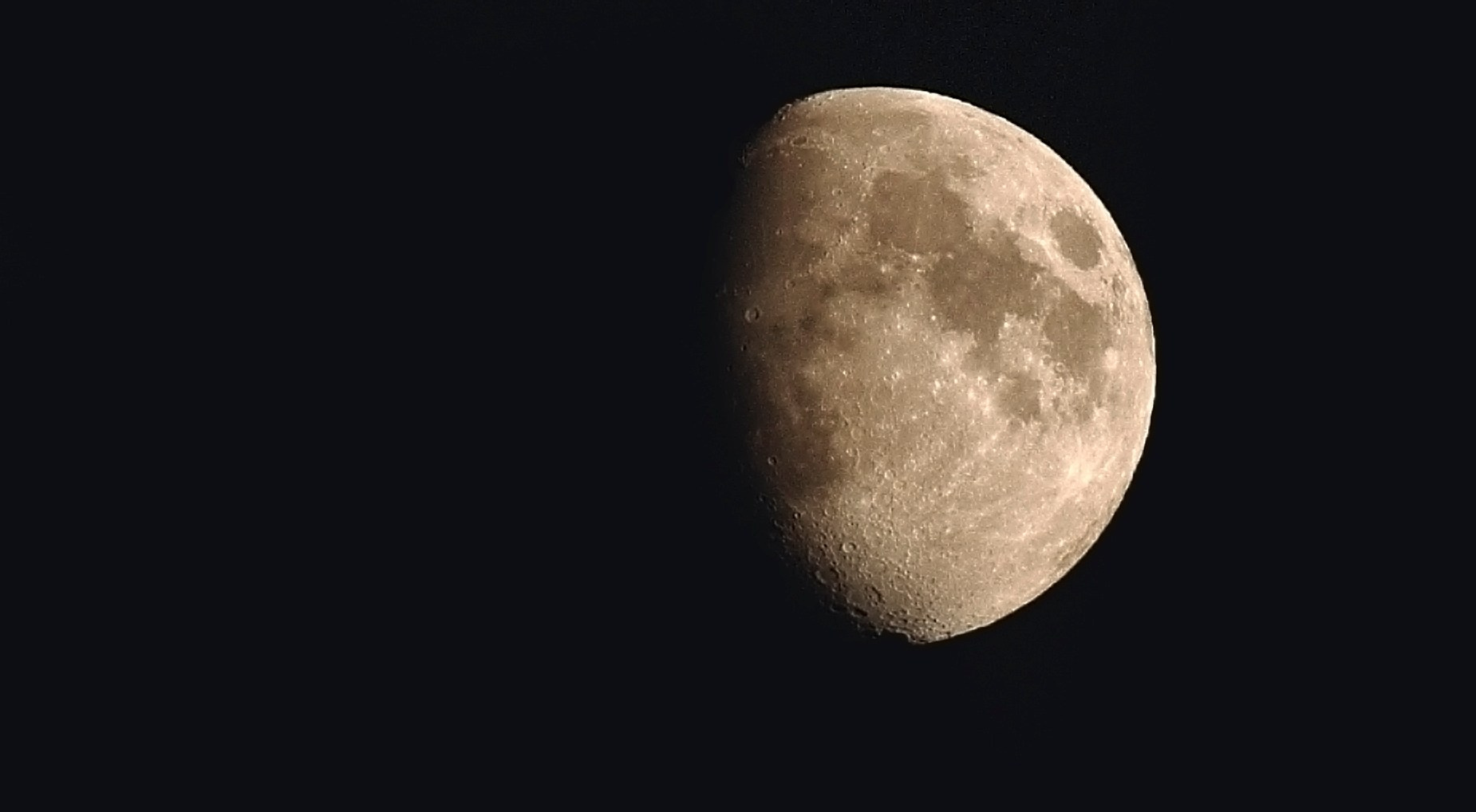 Фотография Луны в gibbous фазе на черном фоне ночного неба, детально видны кратеры и лунные моря, астрономическая фотография поверхности спутника Земли