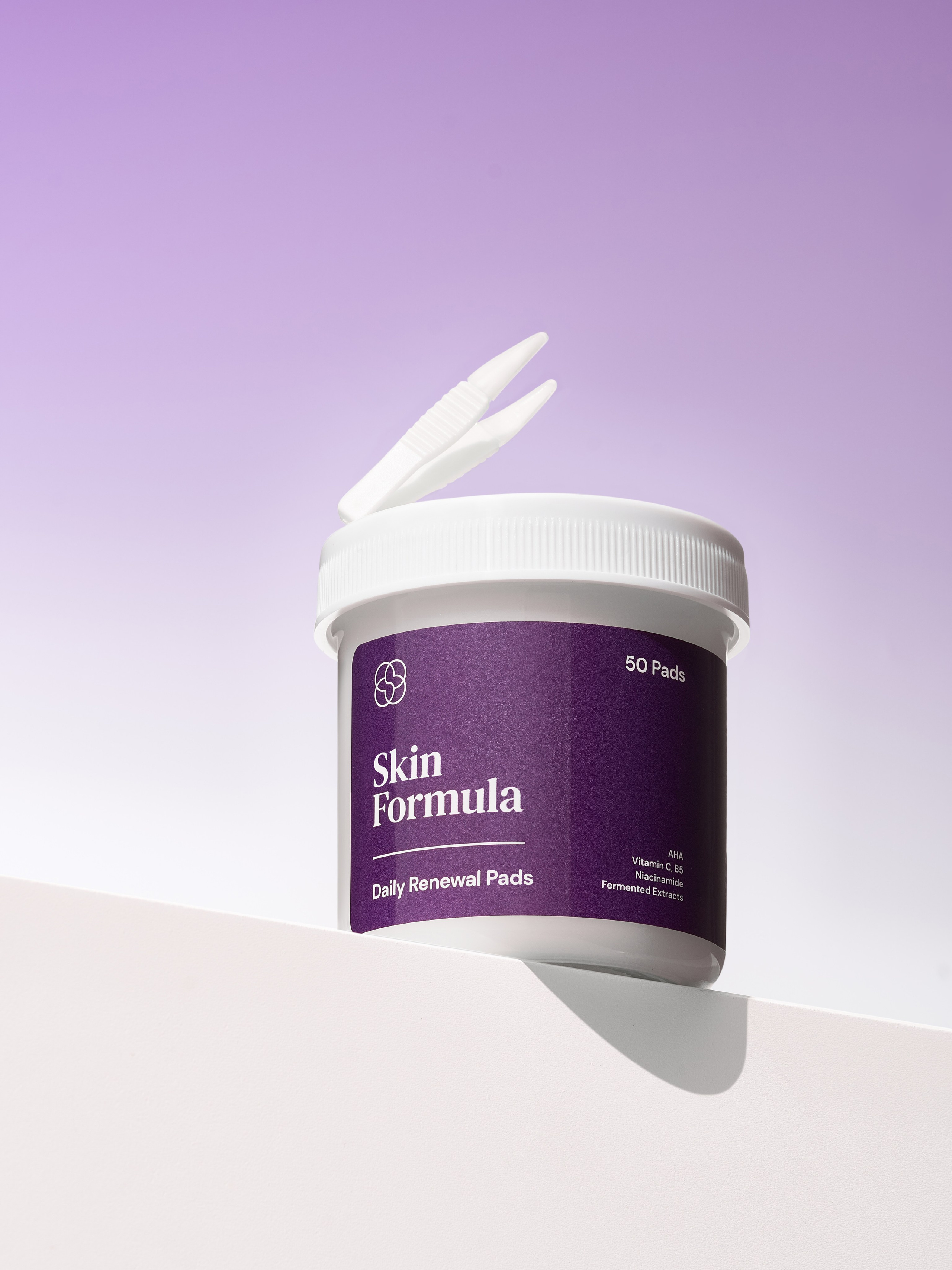 Фиолетовая банка с салфетками на фиолетовом фоне, а сверху пинцет