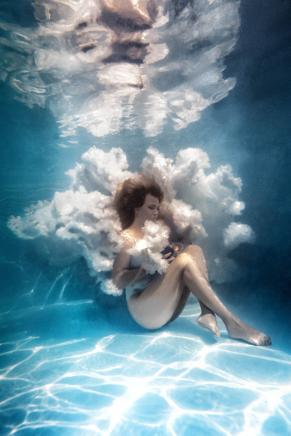 подводная фотосессия во владивостоке - фотосессии под водой в бассейне или в море, Девушка в белом пышном платье в позе эмбриона сидит на дне бассейна