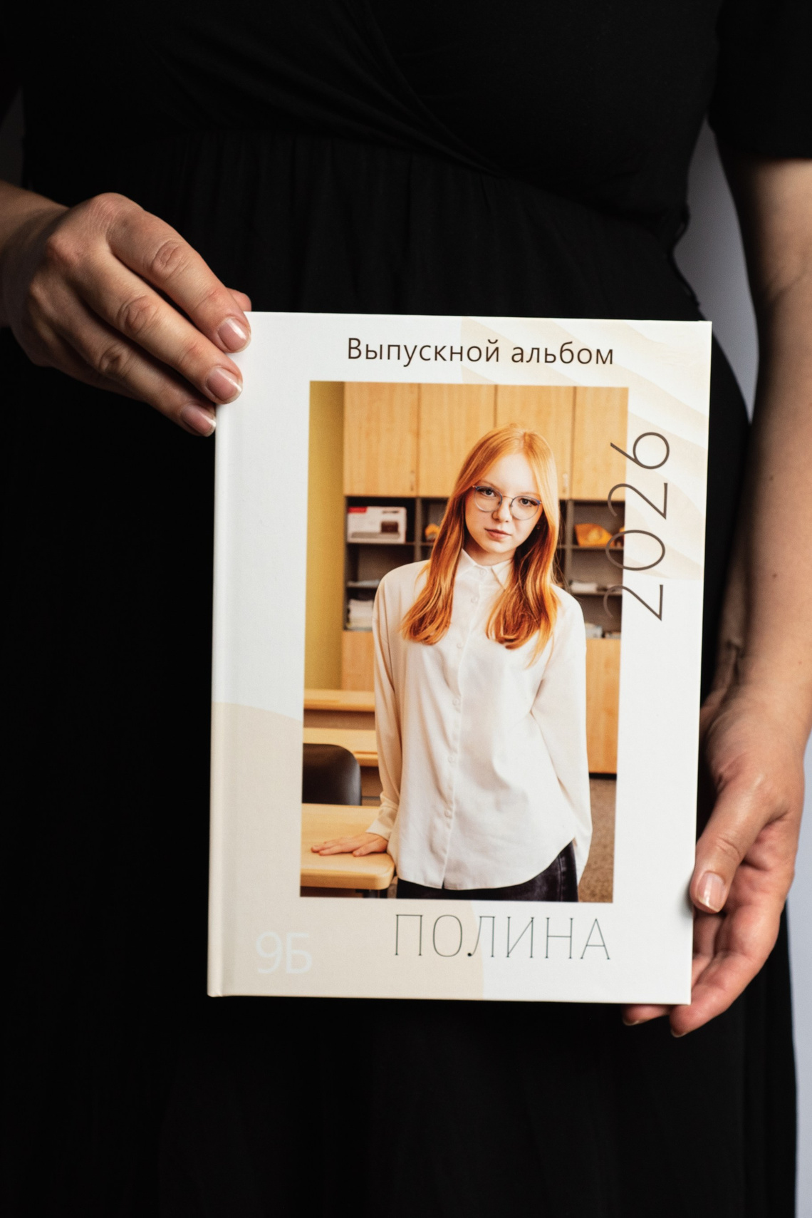 Выпускной фотоальбом в руках фотографа