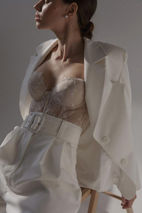 Девушка в белом классическом костюме и кружевном бюстье. Фотосессия в студии.