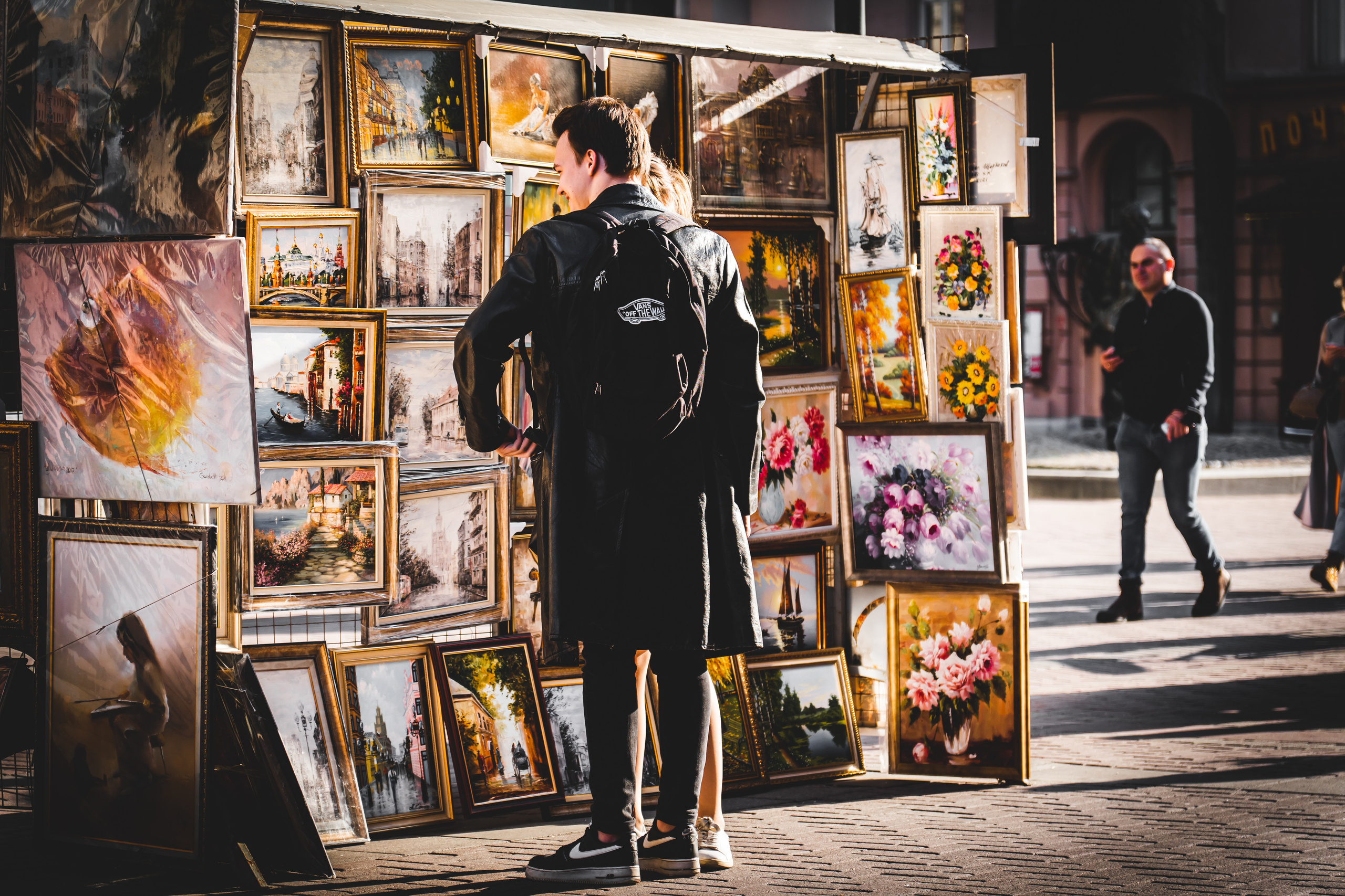 Человек у лотка с картинами на Старом Арбате в Москве