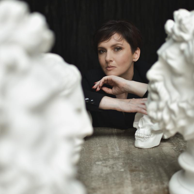 Девушка с короткой стрижкой среди статуй