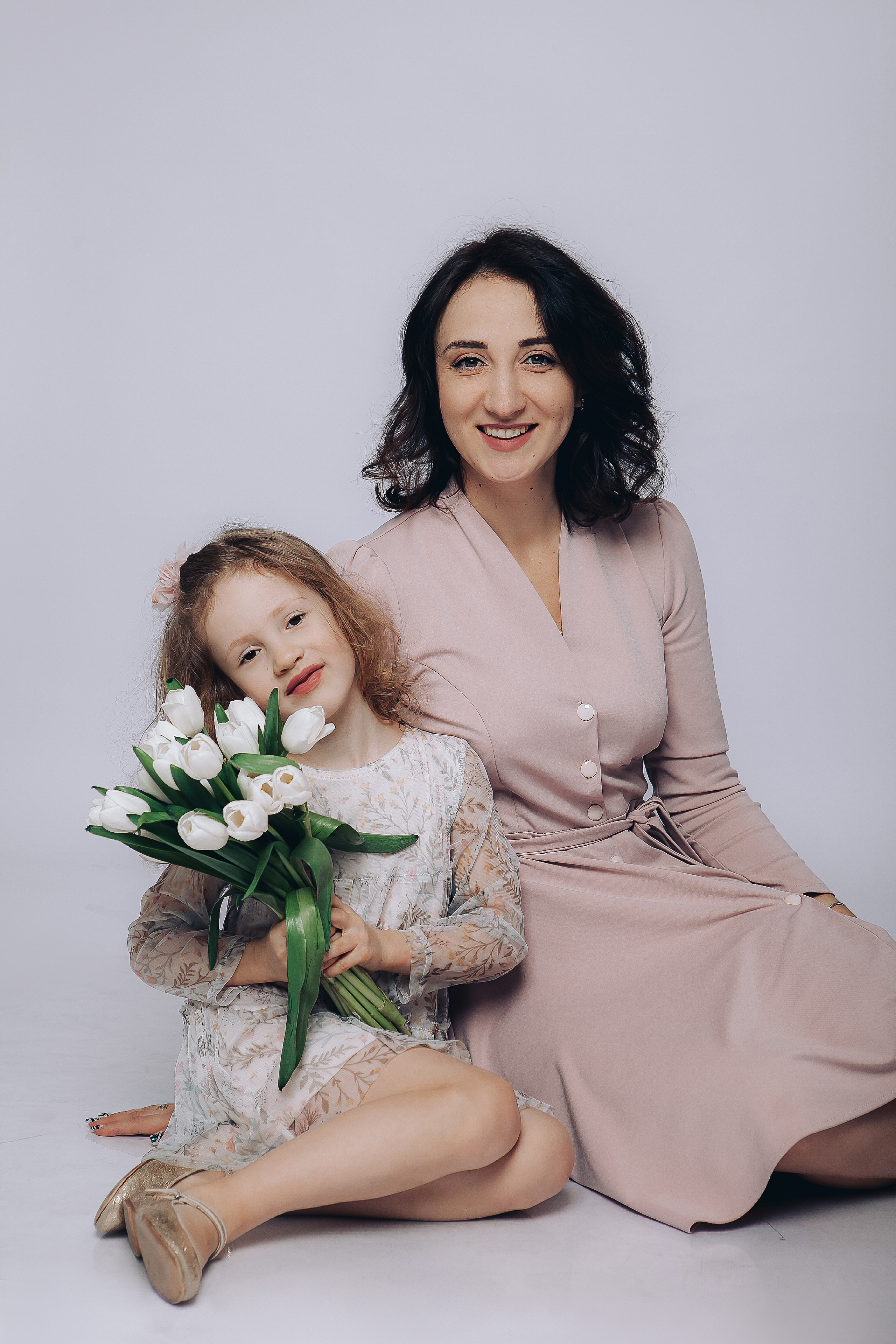 Мама и дочка в пудровых платьях с белыми тюльпанами.