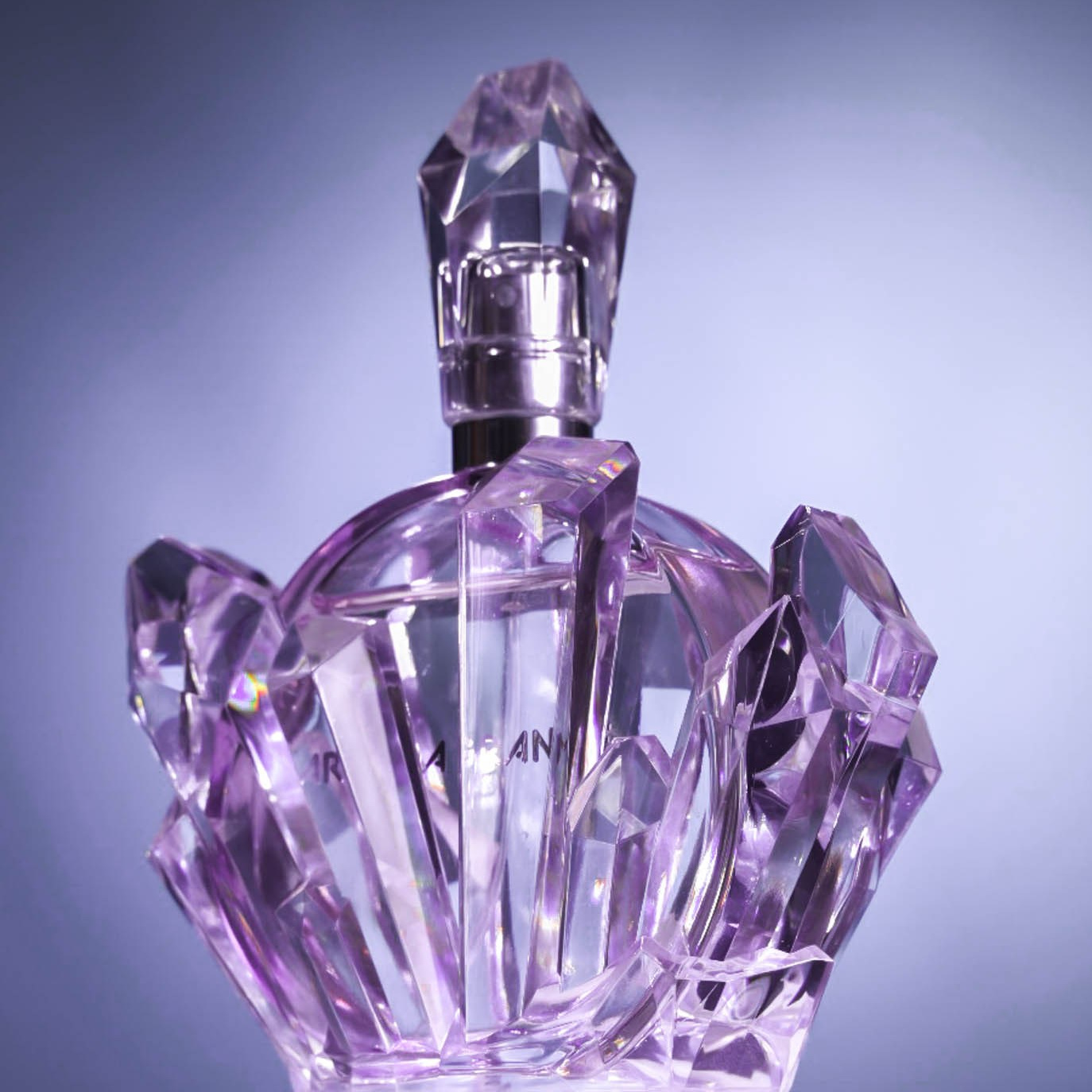 Рекламная фотография духов необычной формы на фиолетовом фоне