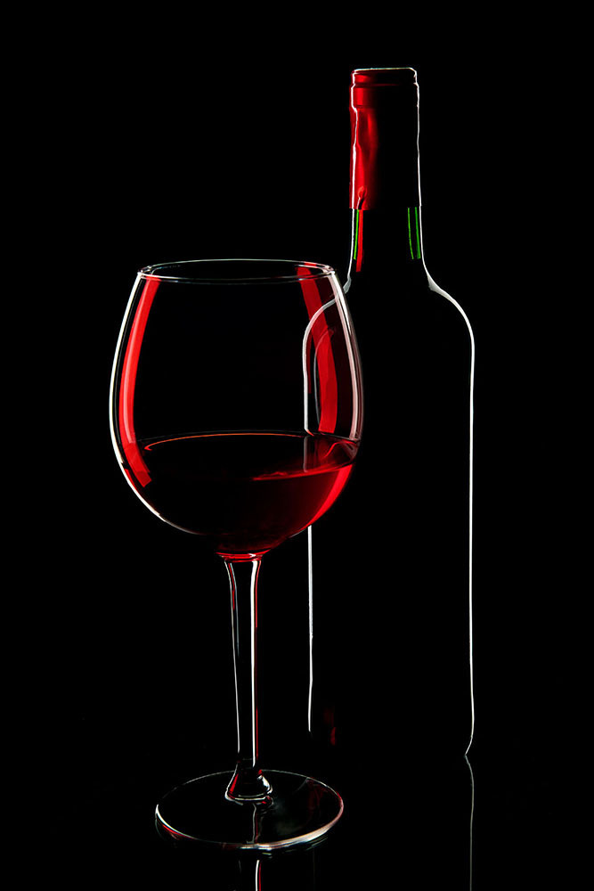 Пример предметной съемки на черном фоне - бутылка с бокалом , грани очерчены светом и цветные блики