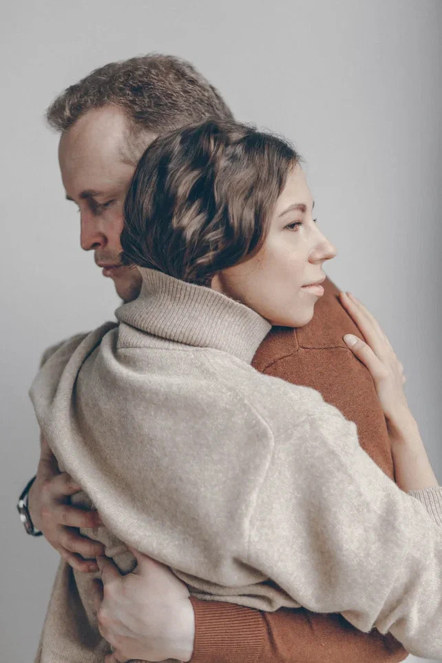 фотография молодой пары в обнимку на светлом фоне. Это муж и жена на семейной фотосессии