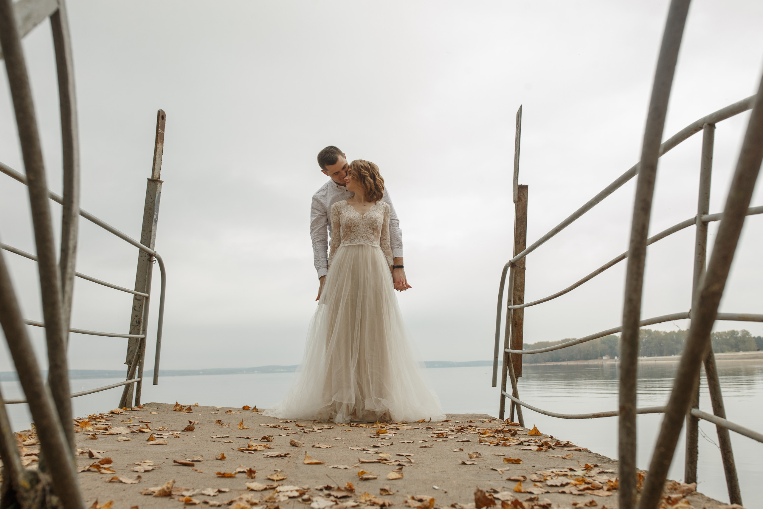 Свадебная прогулка красивой пары на берегу озера