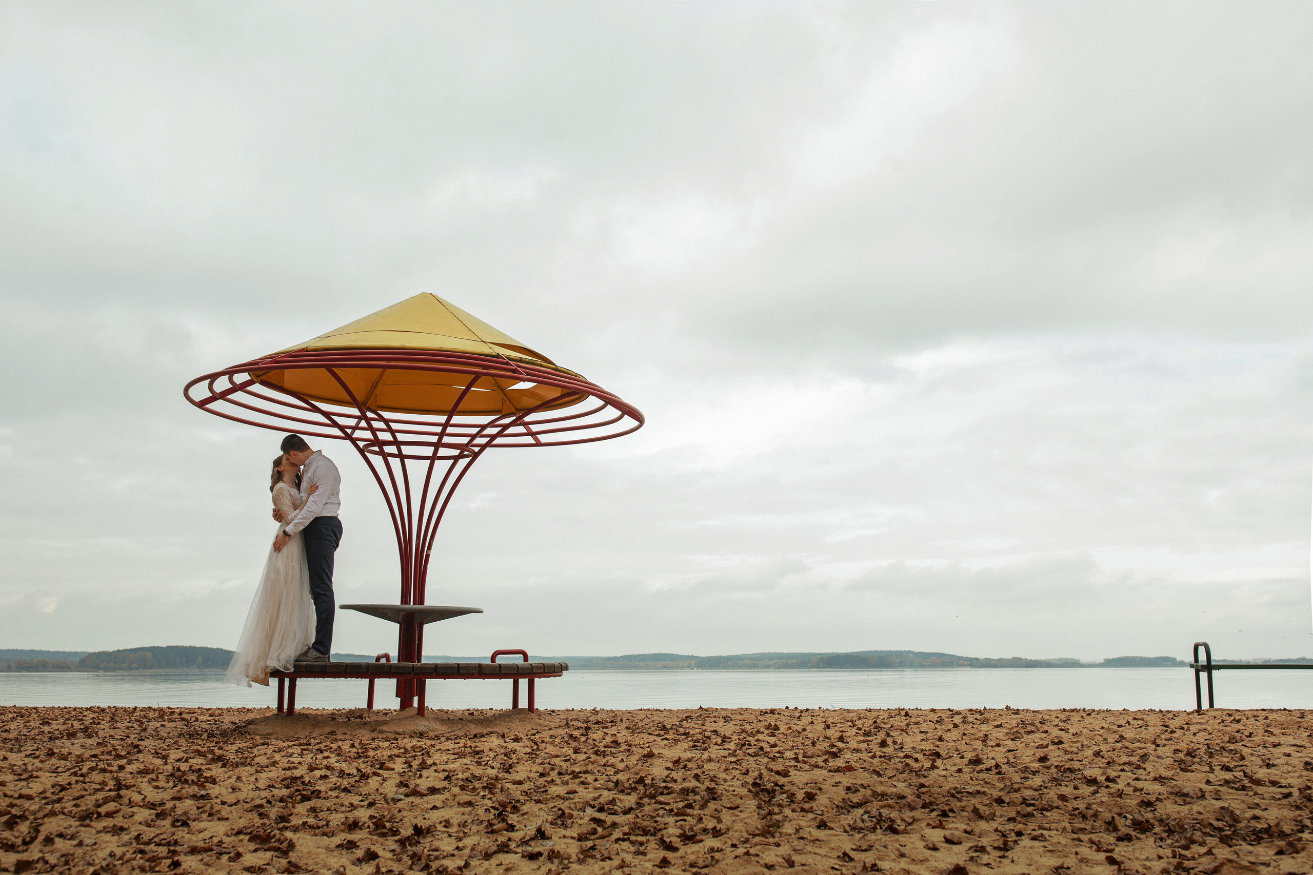 Свадебная прогулка красивой пары на берегу озера