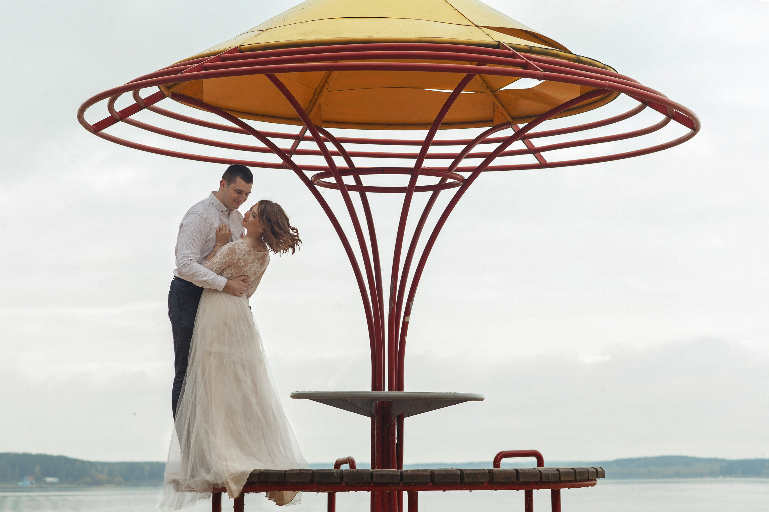 Свадебная прогулка красивой пары на берегу озера