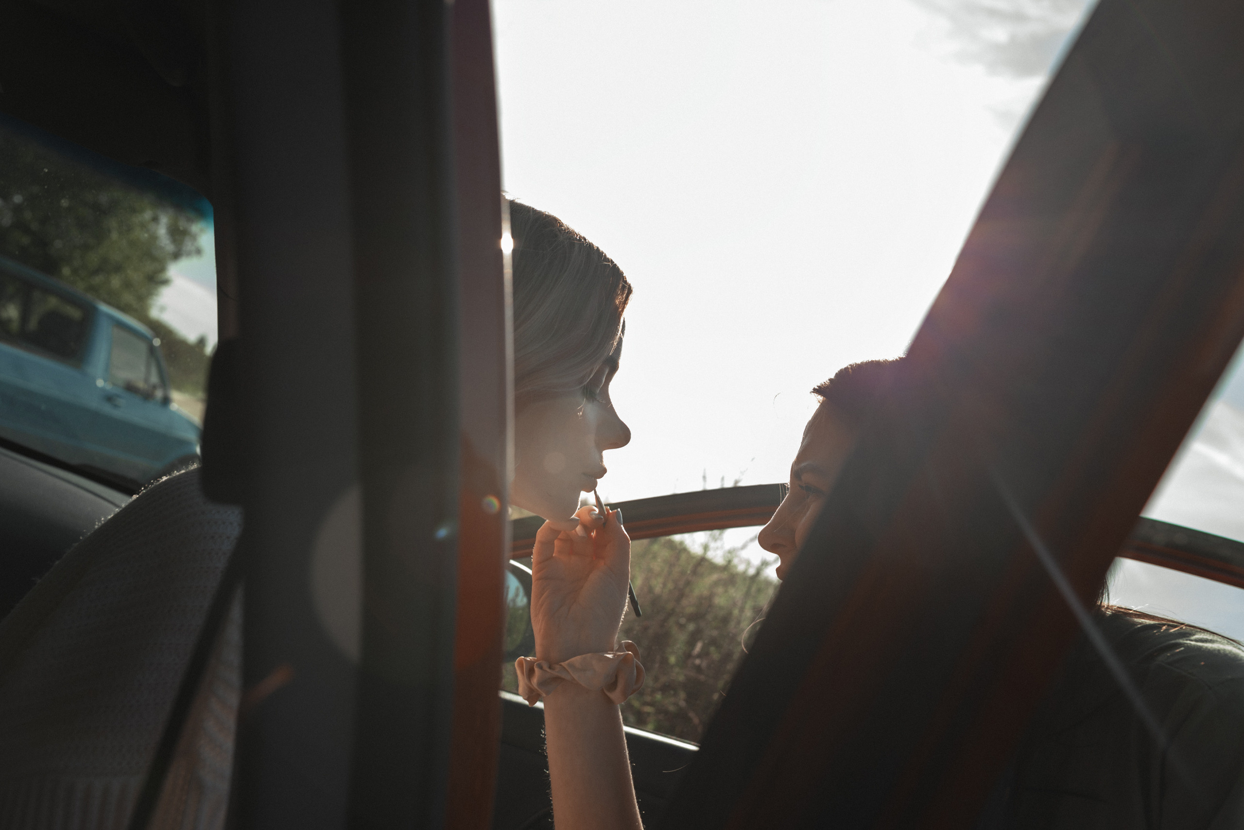 Опытный стилист делает невесте мэйк и прическу для фотосессии.