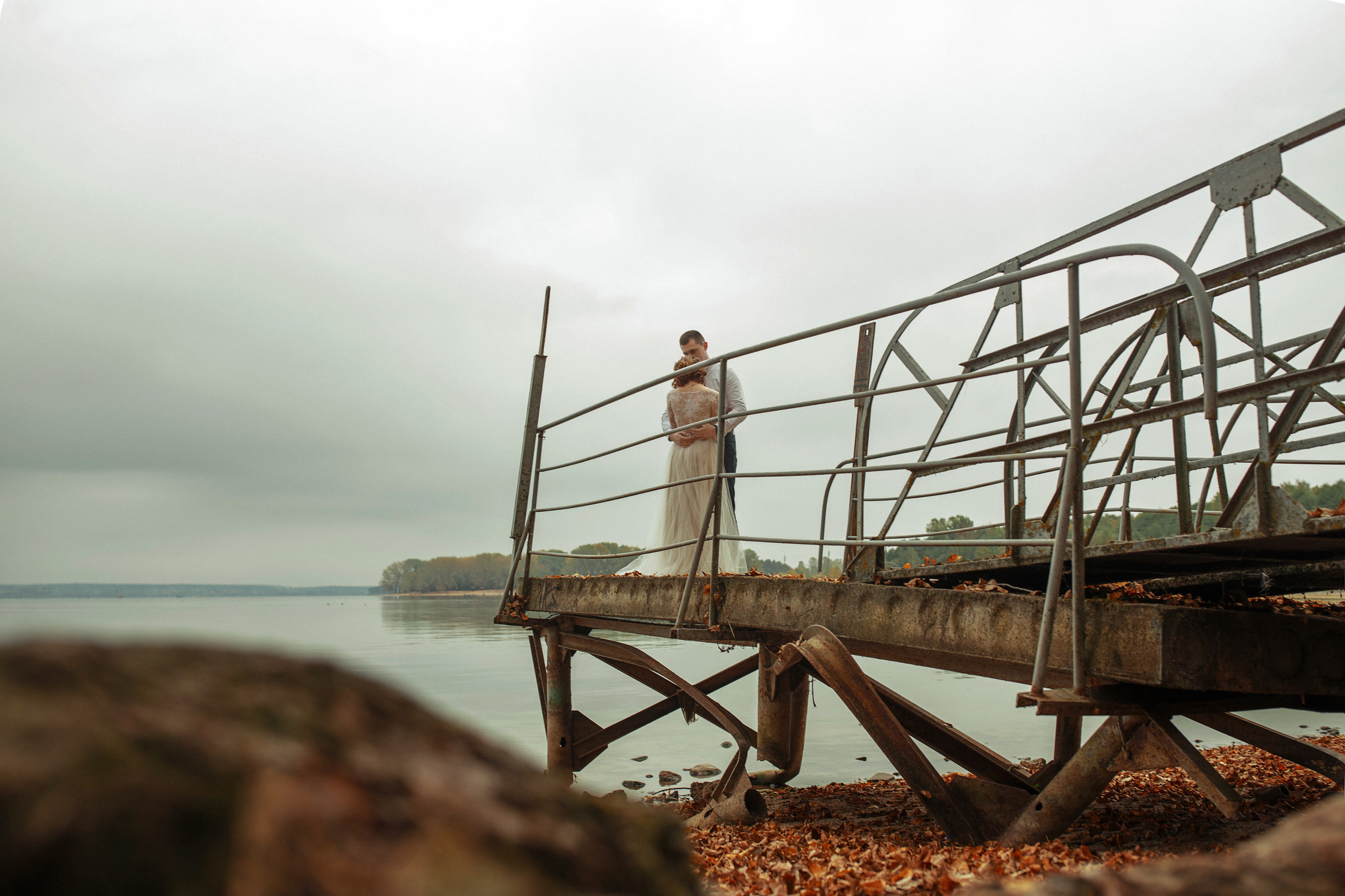 Свадебная прогулка красивой пары на берегу озера