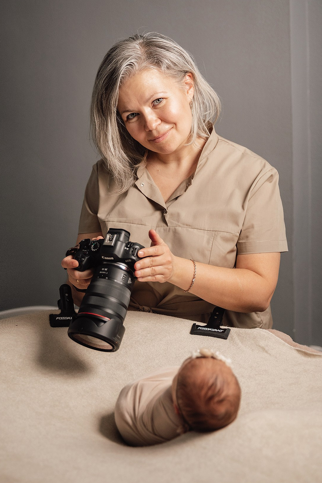 Фотограф Наташа Давыдова в процессе творческой съемки новорожденного.