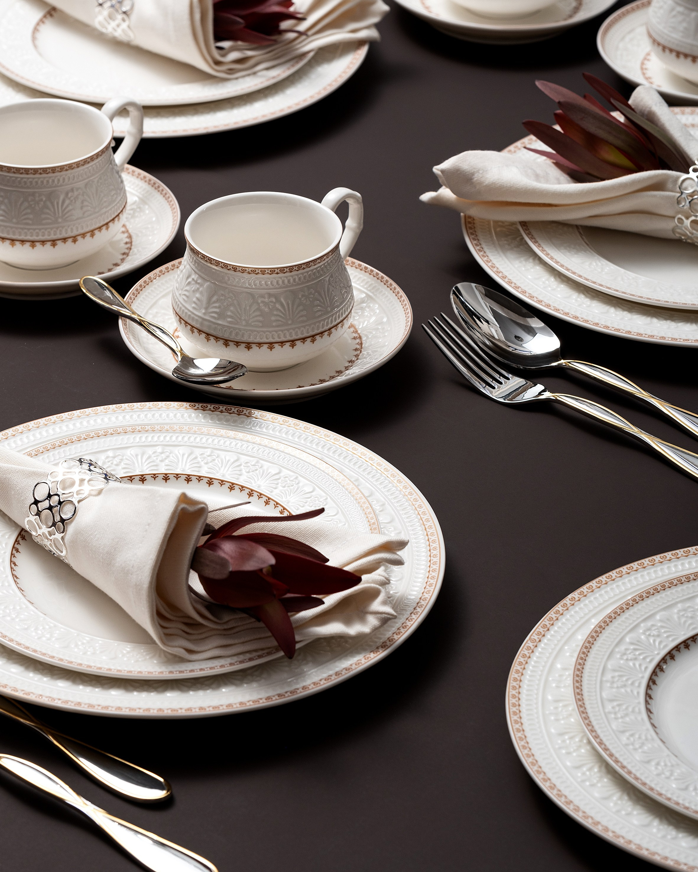 Сервировка с белыми салфетками и бордовыми акцентами на тёмном фоне
