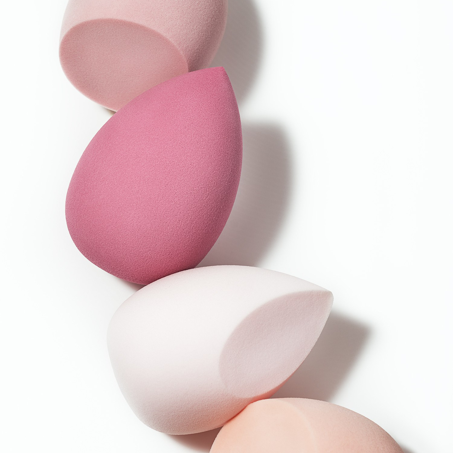 Каталожное фото спонжи для макияжа на белом фоне