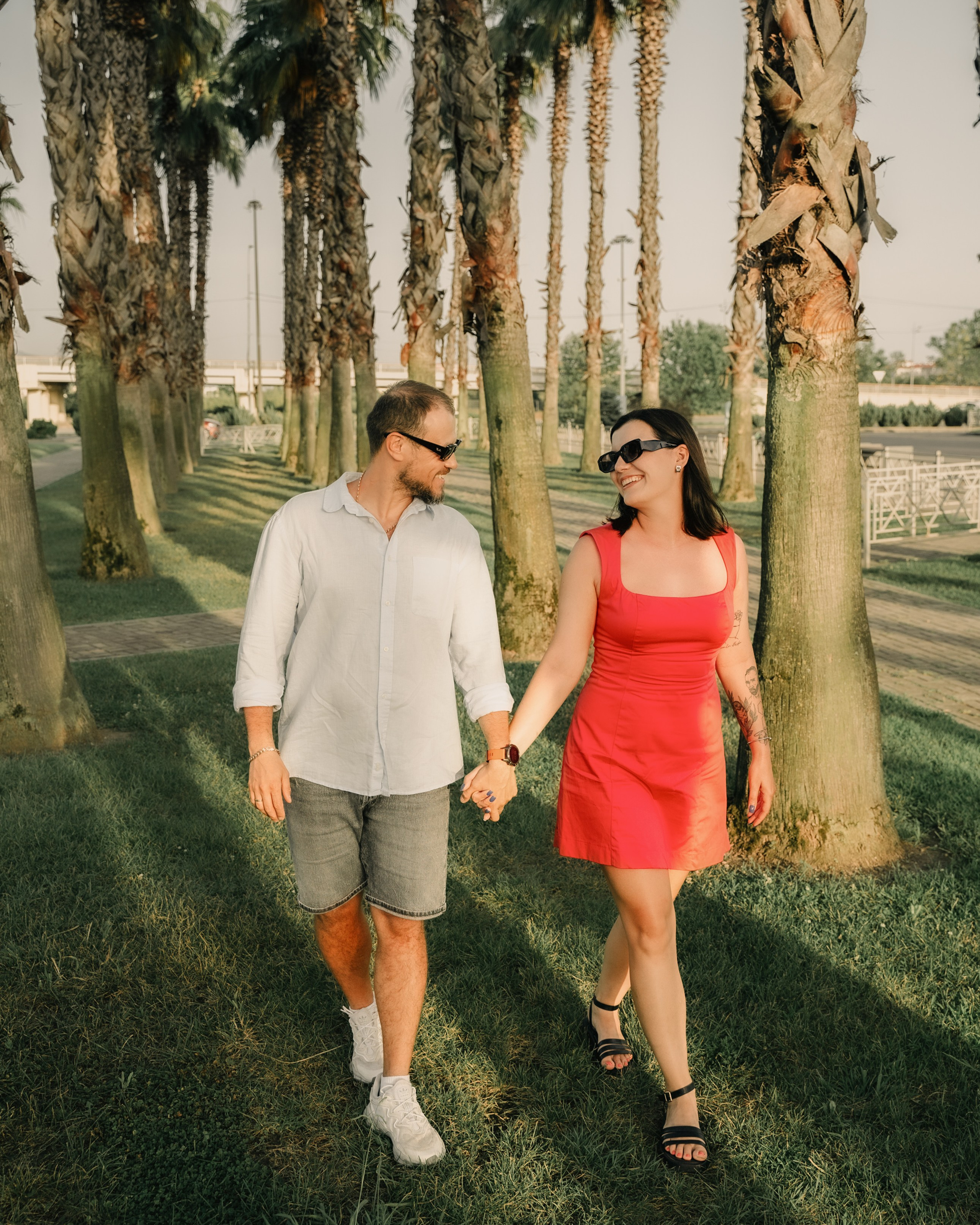 Фотоснимок пары гуляющей по пальмовой алеи