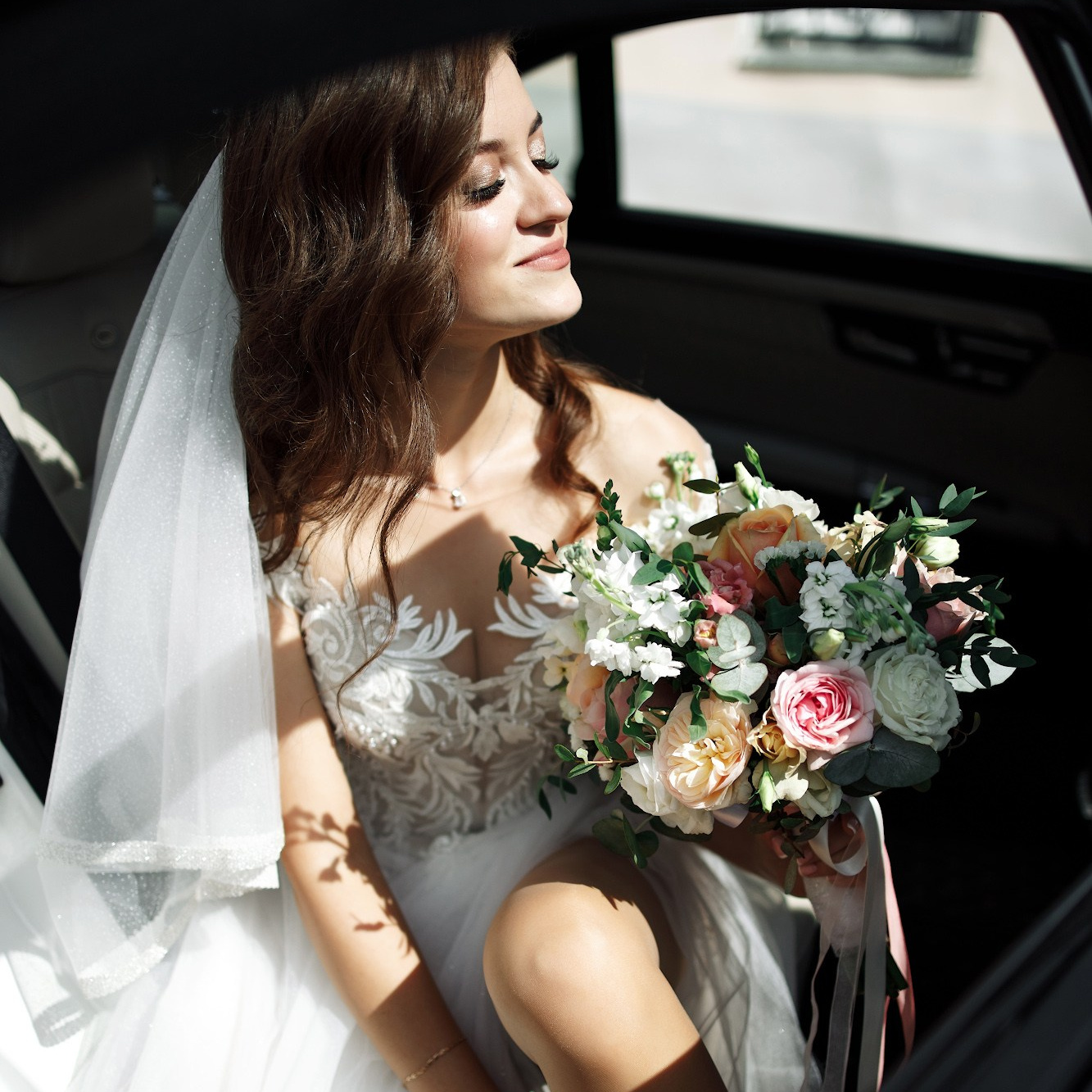 невеста крупным планом сидит в машине с букетом