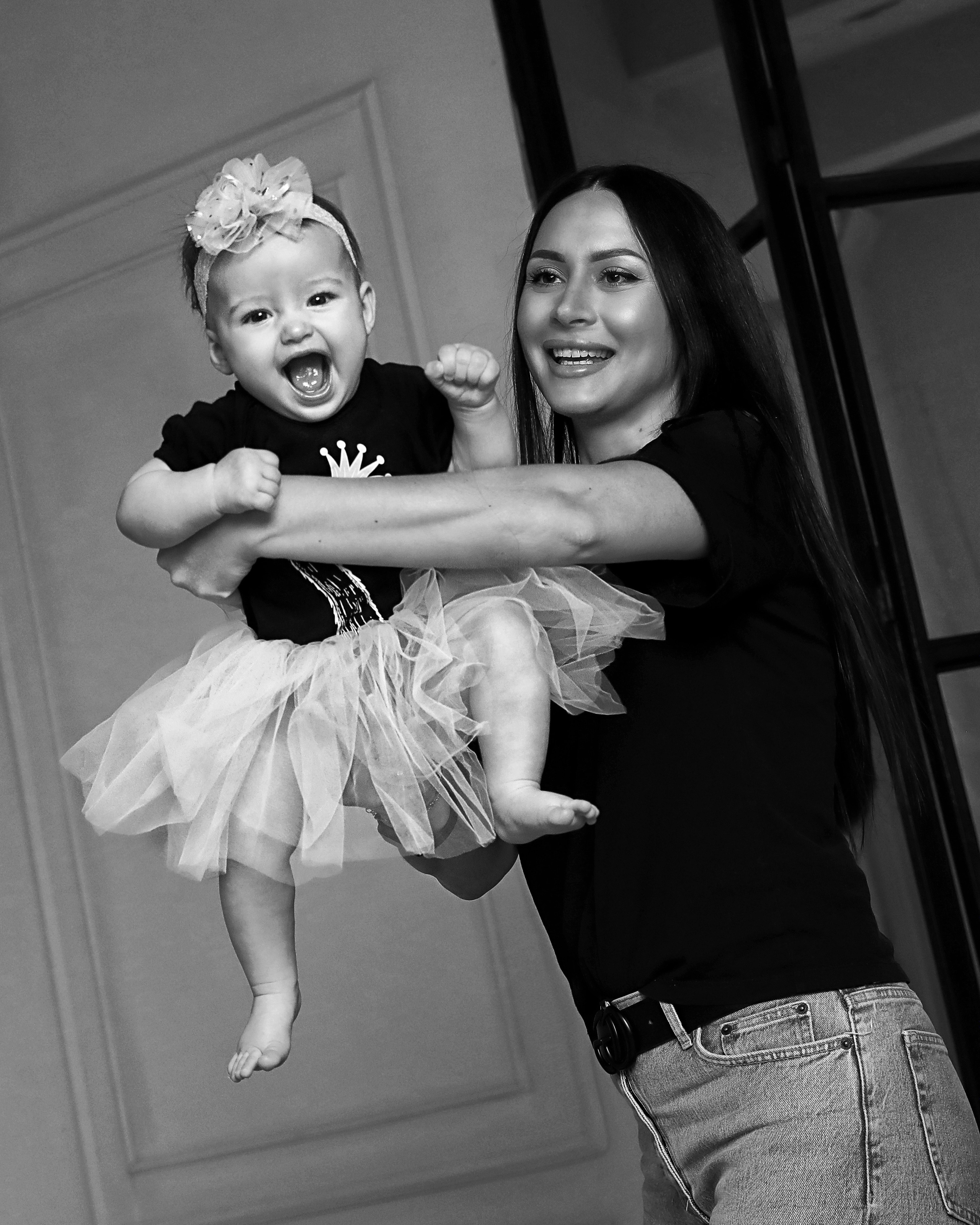 Малышка смеётся на руках у мамы