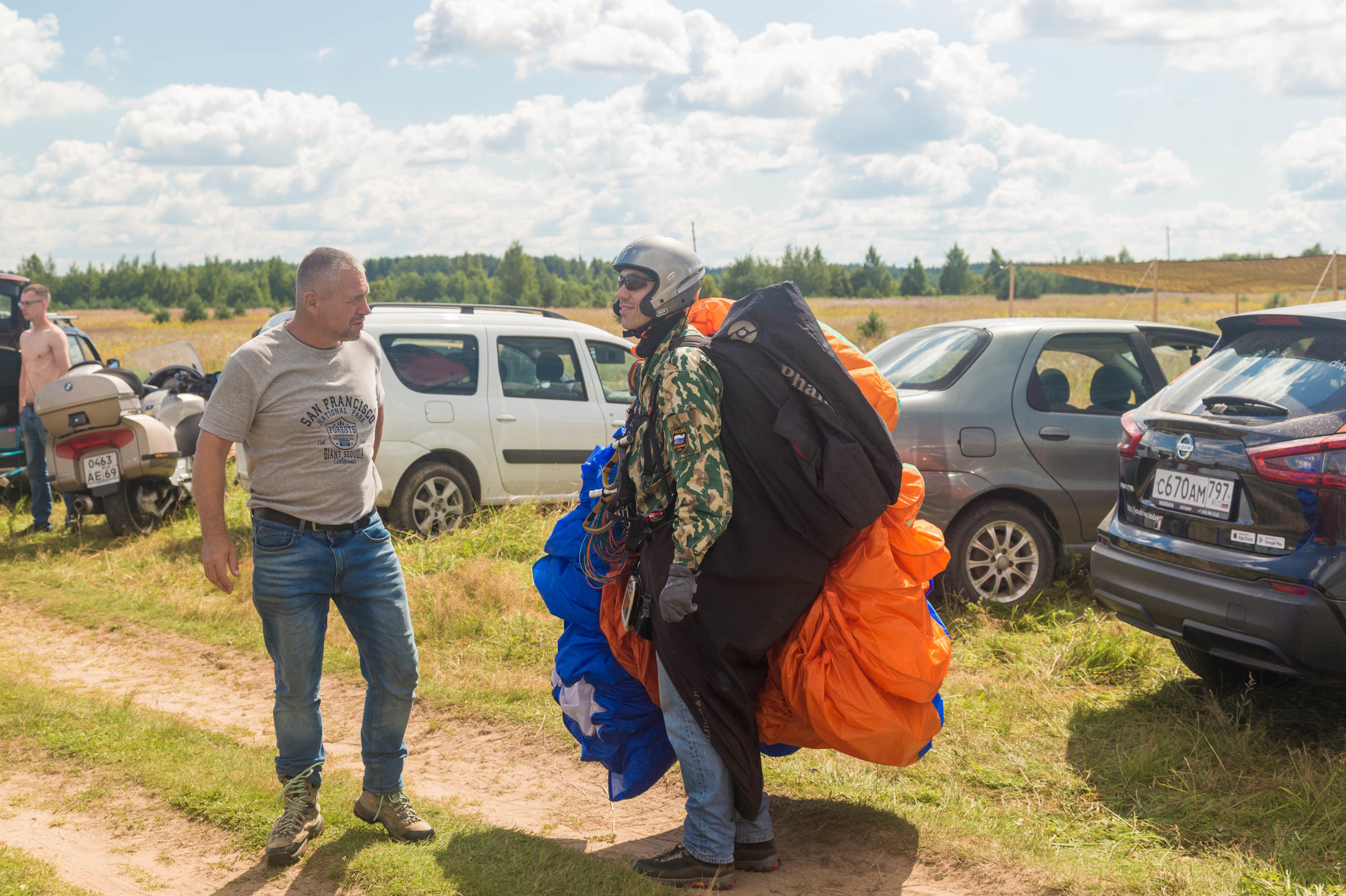 Пилот параплана держит свой парашют