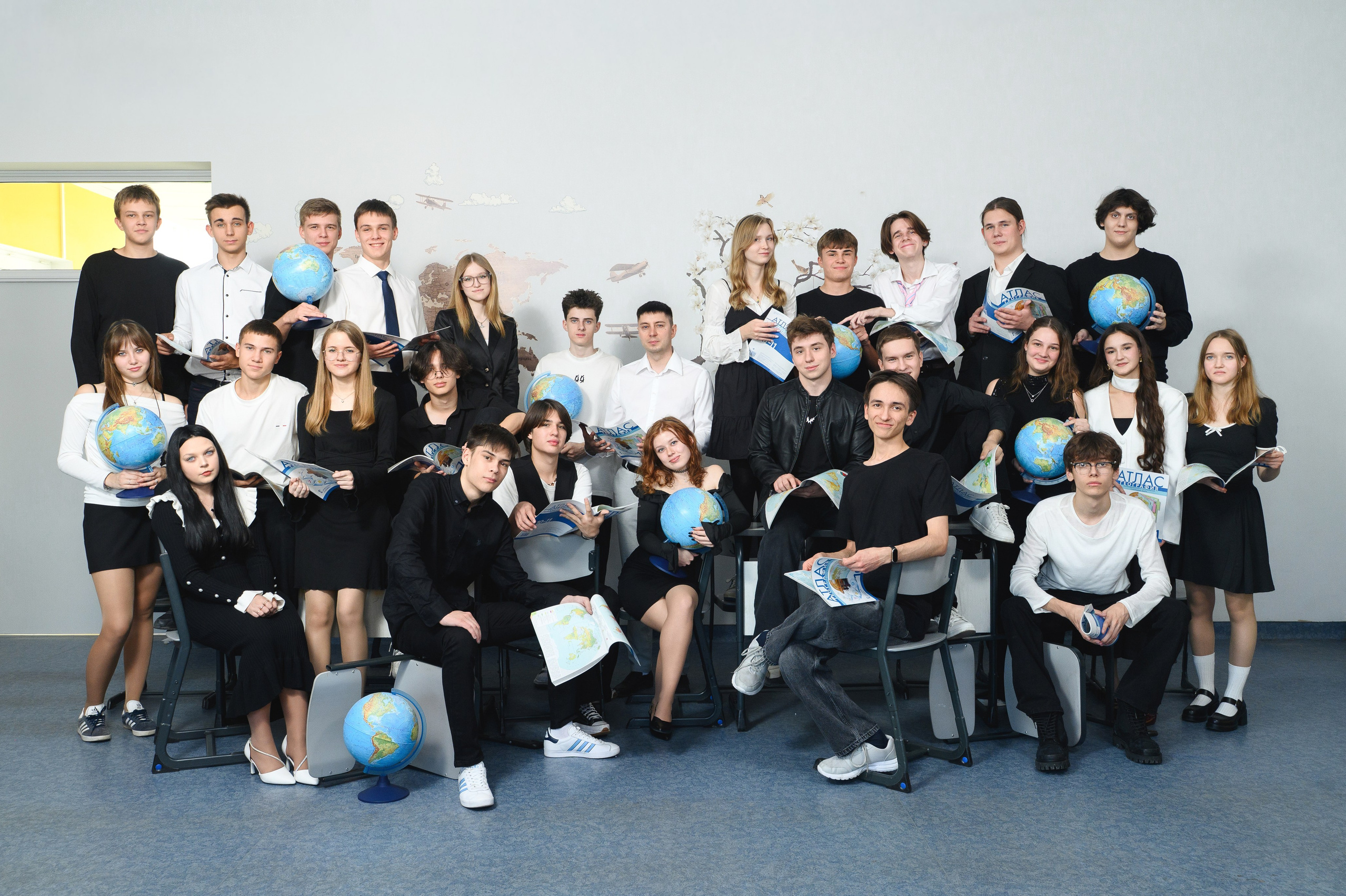 Общее фото в классе с классным руководителем и глобусами в руках у некоторых учеников. 