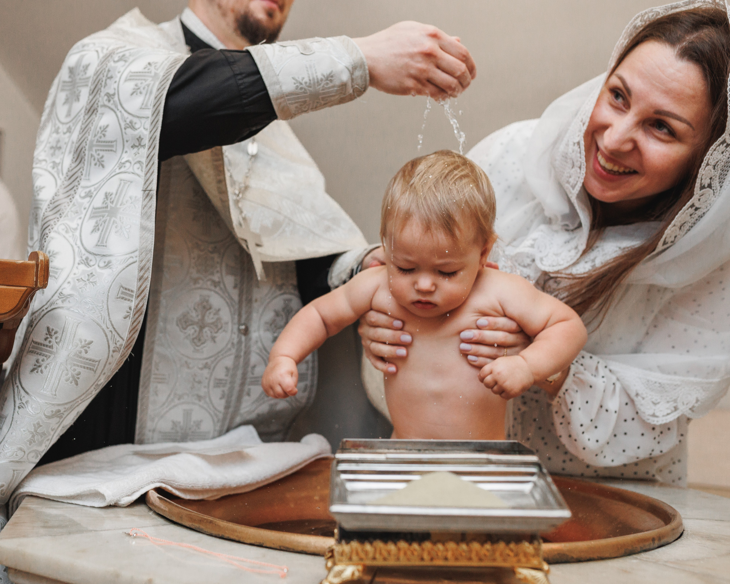 Крёстные с ребёнком у купели