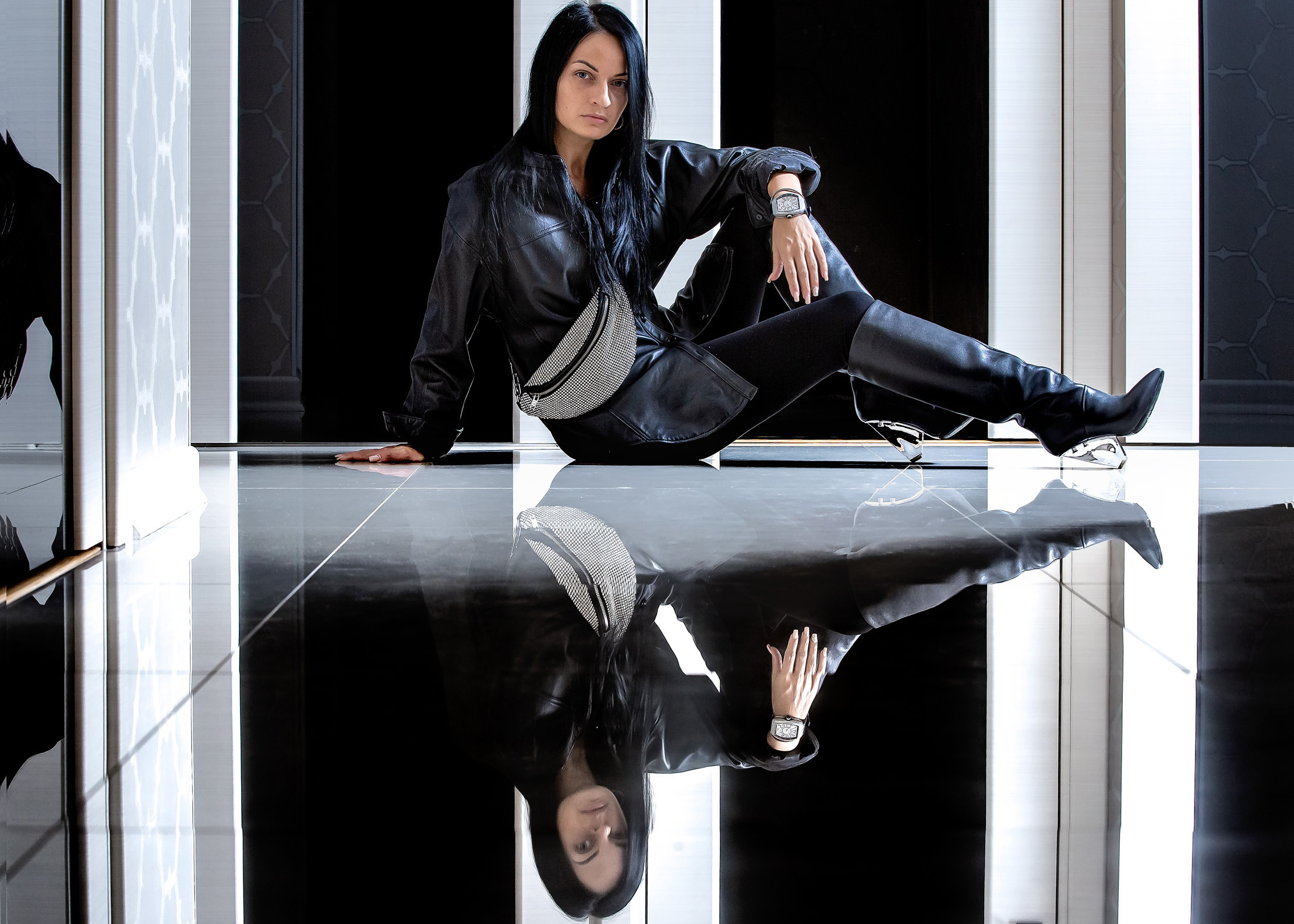 девушка в сапогах сидит на зеркальном полу