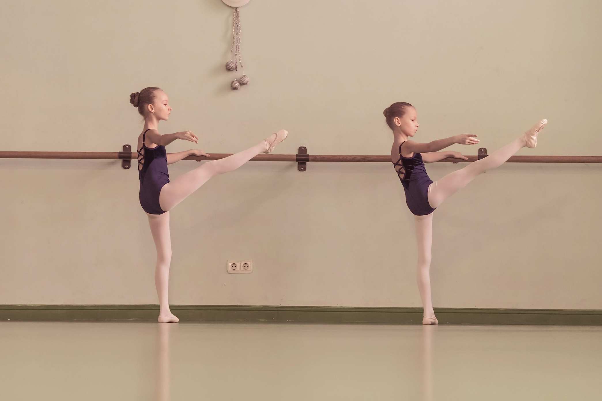 девочки занимаются у хореографического станка