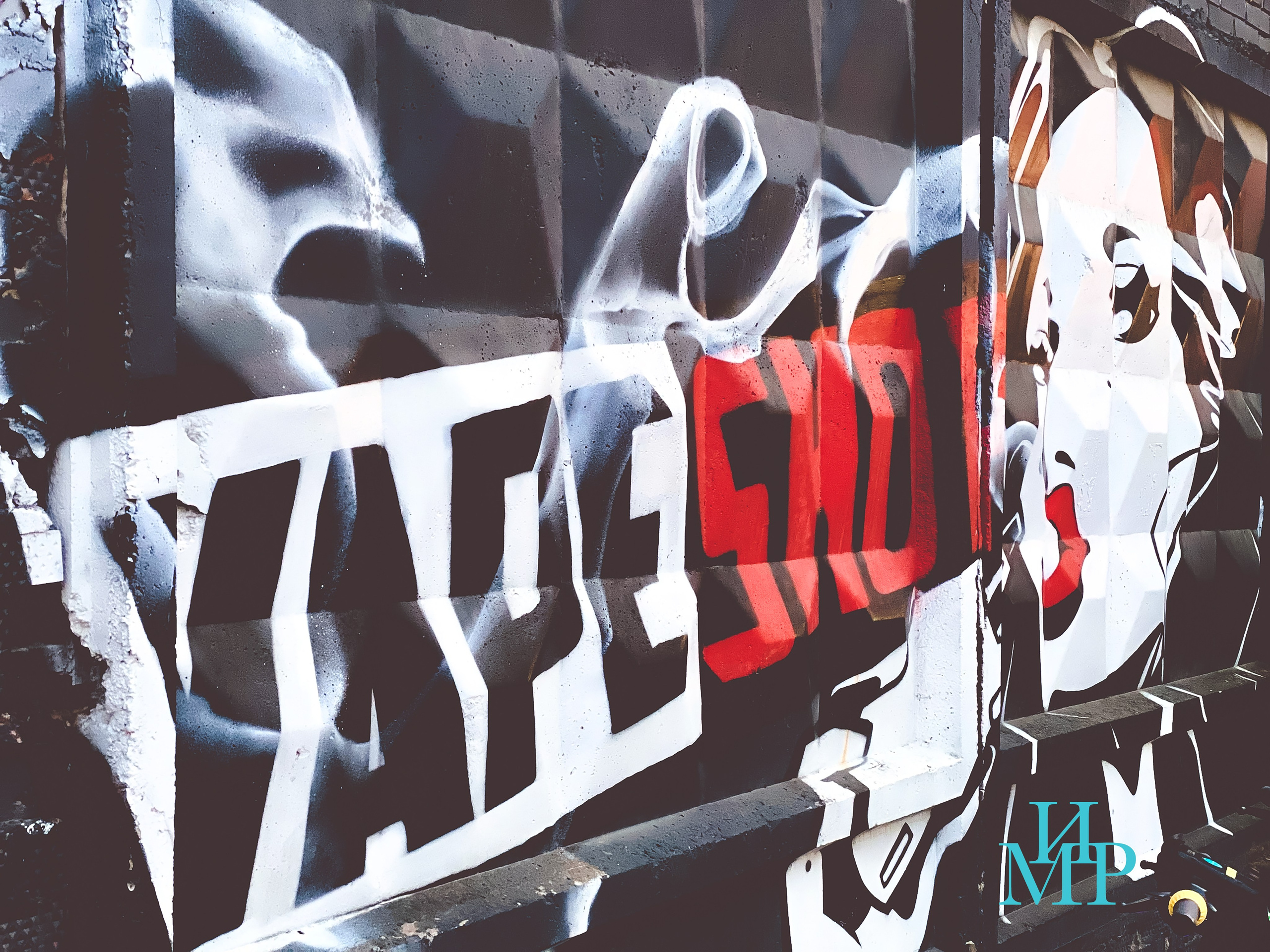 Граффити на бетонной стене с изображением девушки, выпускающей вейп-пар, надпись “Vape Shop”; художественная фотография, снятая снизу, с акцентом на атмосферу уличной культуры и тему вейпов.