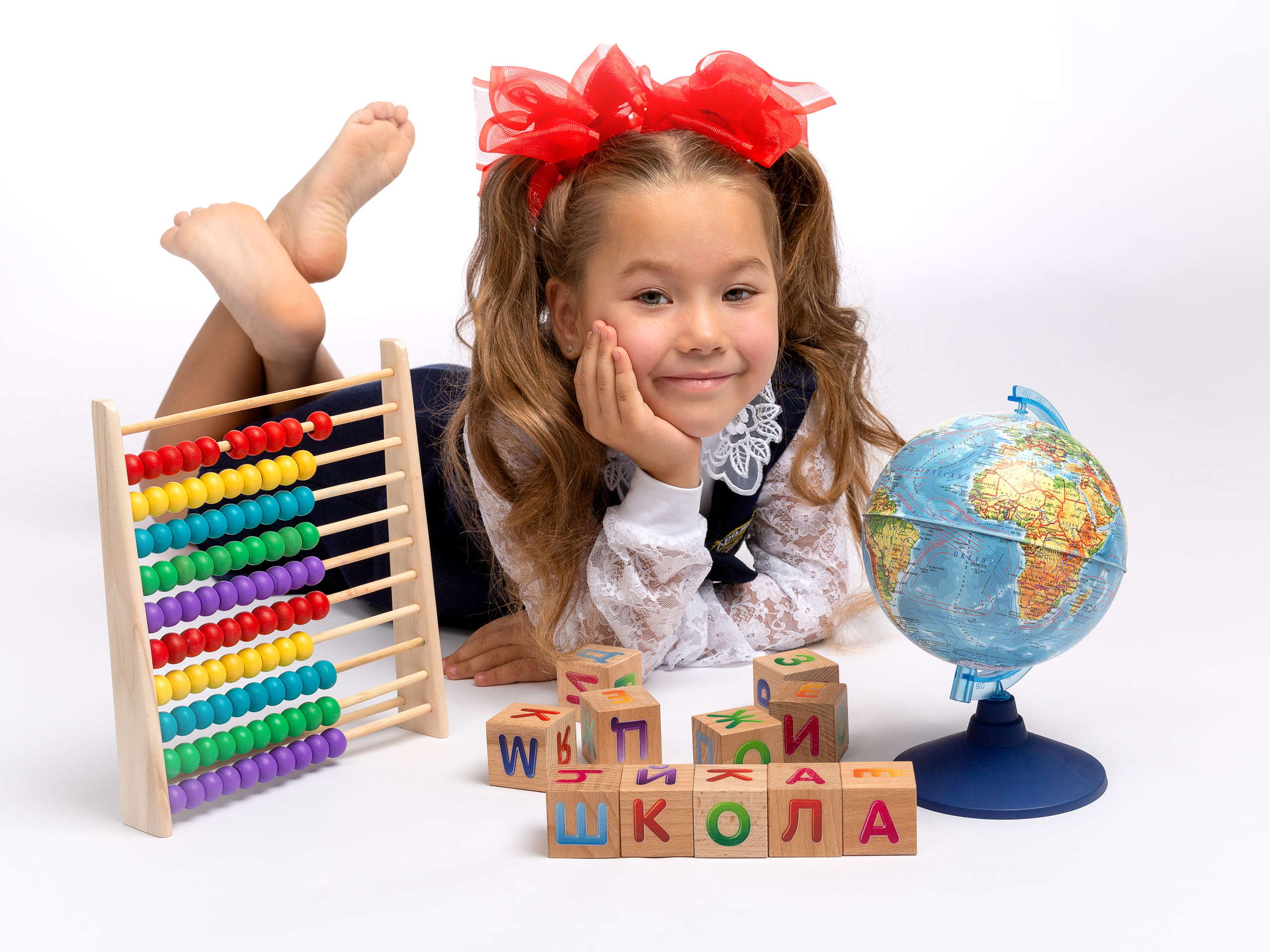 Первоклашка сложила из деревянных кубиков слово школа.