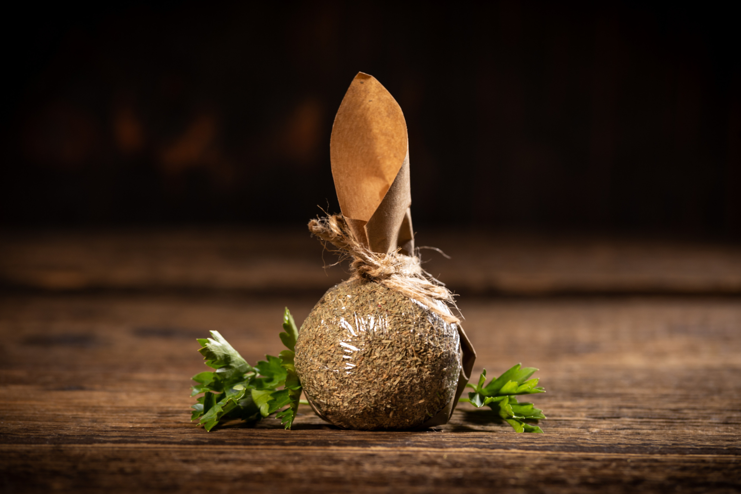 Шарик сыра белпер кнолле в обсыпке сушеного укропа, в подарочной упаковке из крафтовой бумаги.