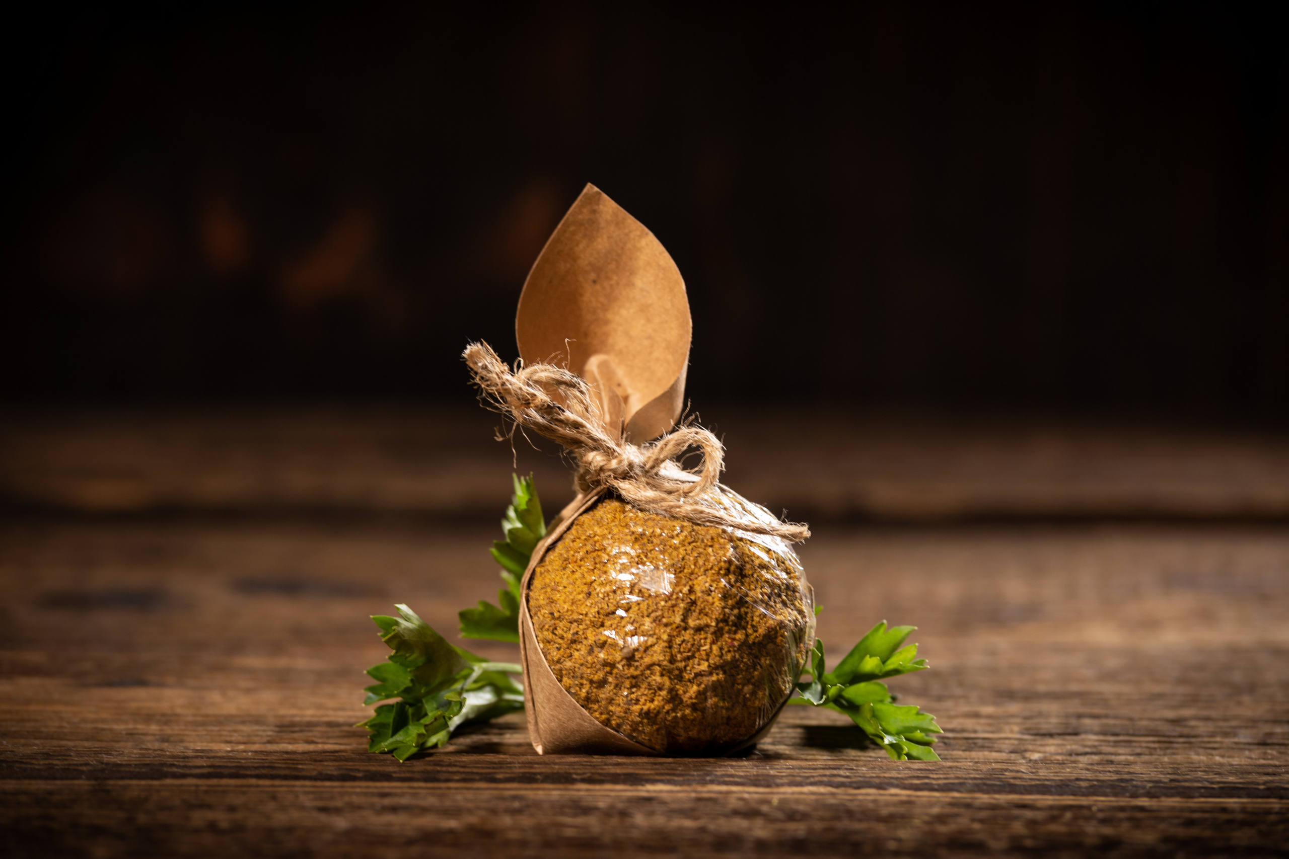 Шарик сыра белпер кнолле в обсыпке карри, в подарочной упаковке из крафтовой бумаги.