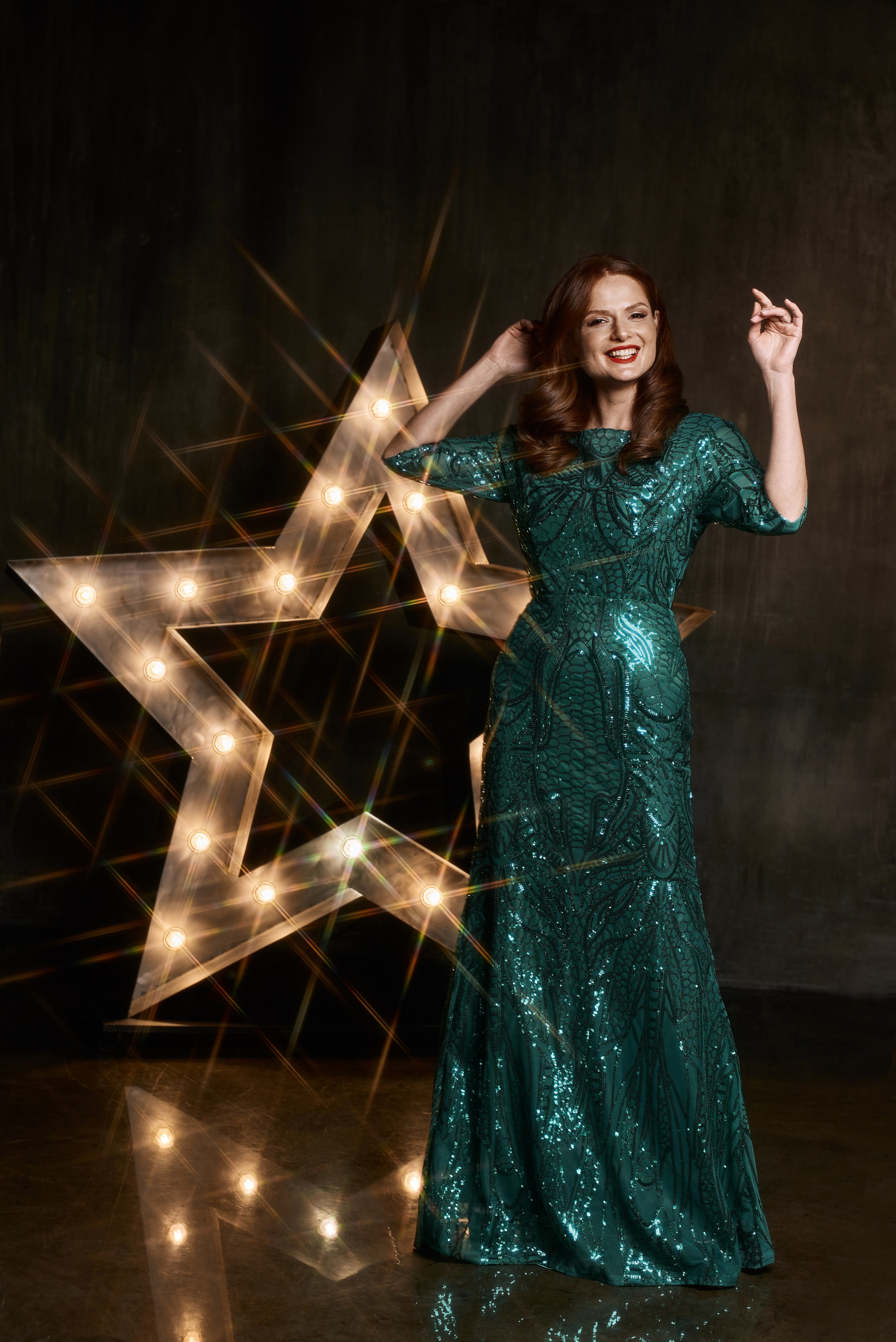 Елена Ландер в стиле ретро в вечернем зеленом платье в пайетках на фоне светящейся звезды