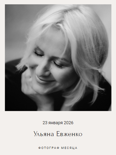 Женщина с светлыми волосами мягко улыбается, опустив взгляд. Чёрно-белый снимок, атмосфера тёплая, спокойная.