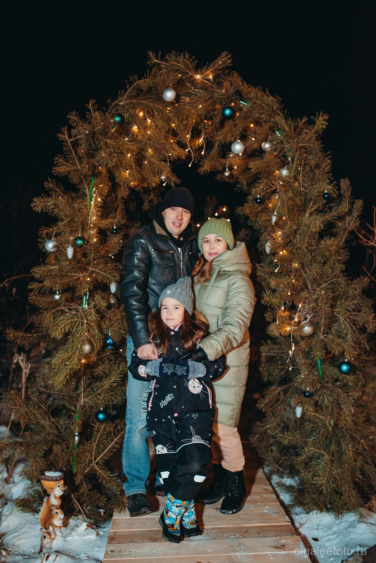 Новогодняя фотосессия для всей семьи в Иркутске Мама папа и дочь и новогодней арки с гирляндами