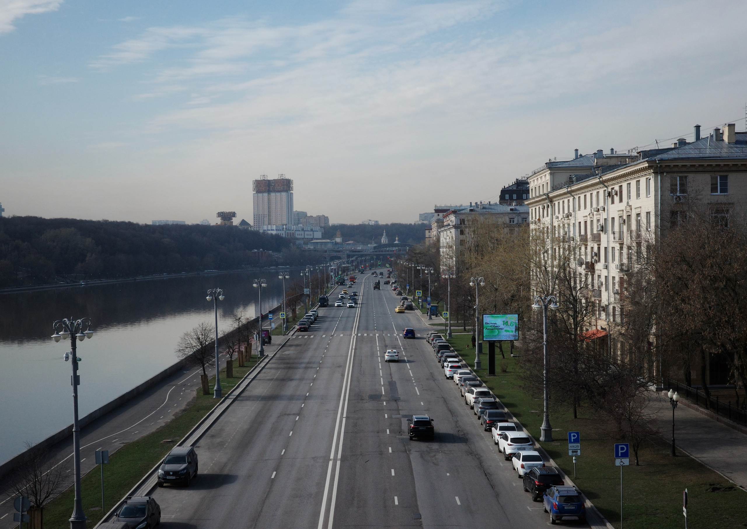 Вид с Андреевского моста в сторону Воробьёвых гор: широкий проспект, река, золотистые башни Президиума РАН