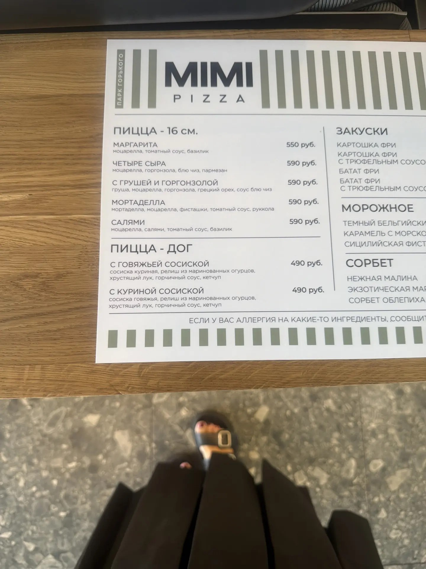 Меню MIMI PIZZA на стойке у входа в ресторан. Демонстрация печатного меню во время фуд-съемки.