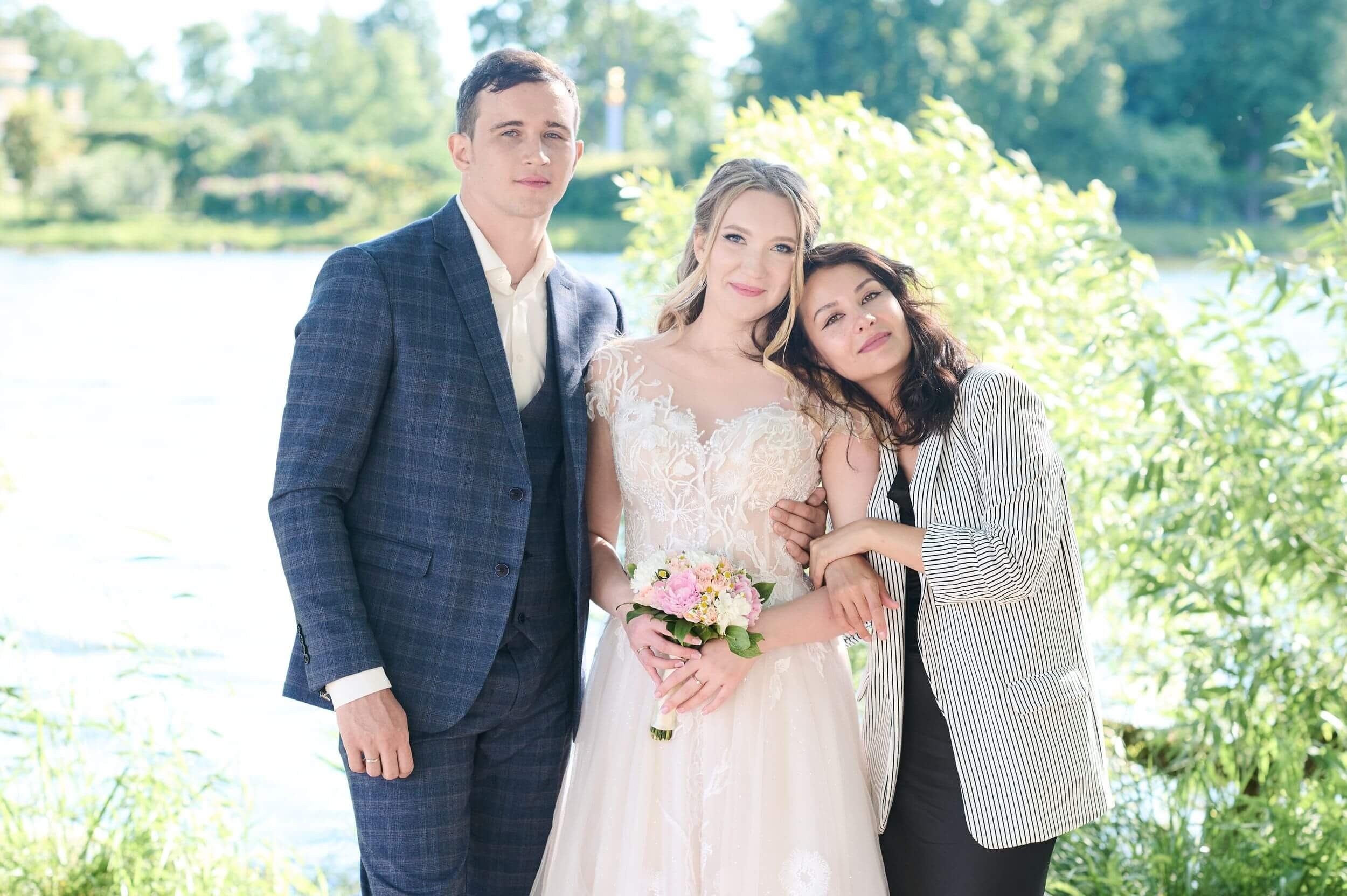 Свадебная группа: молодожёны и гости на фоне Ольгиного пруда рядом с ЗАГСом в Петергофе. Тёплая атмосфера праздника, естественный свет и живописный пейзаж создают гармоничный кадр. Идеальная локация для памятной групповой фотографии сразу после церемонии.