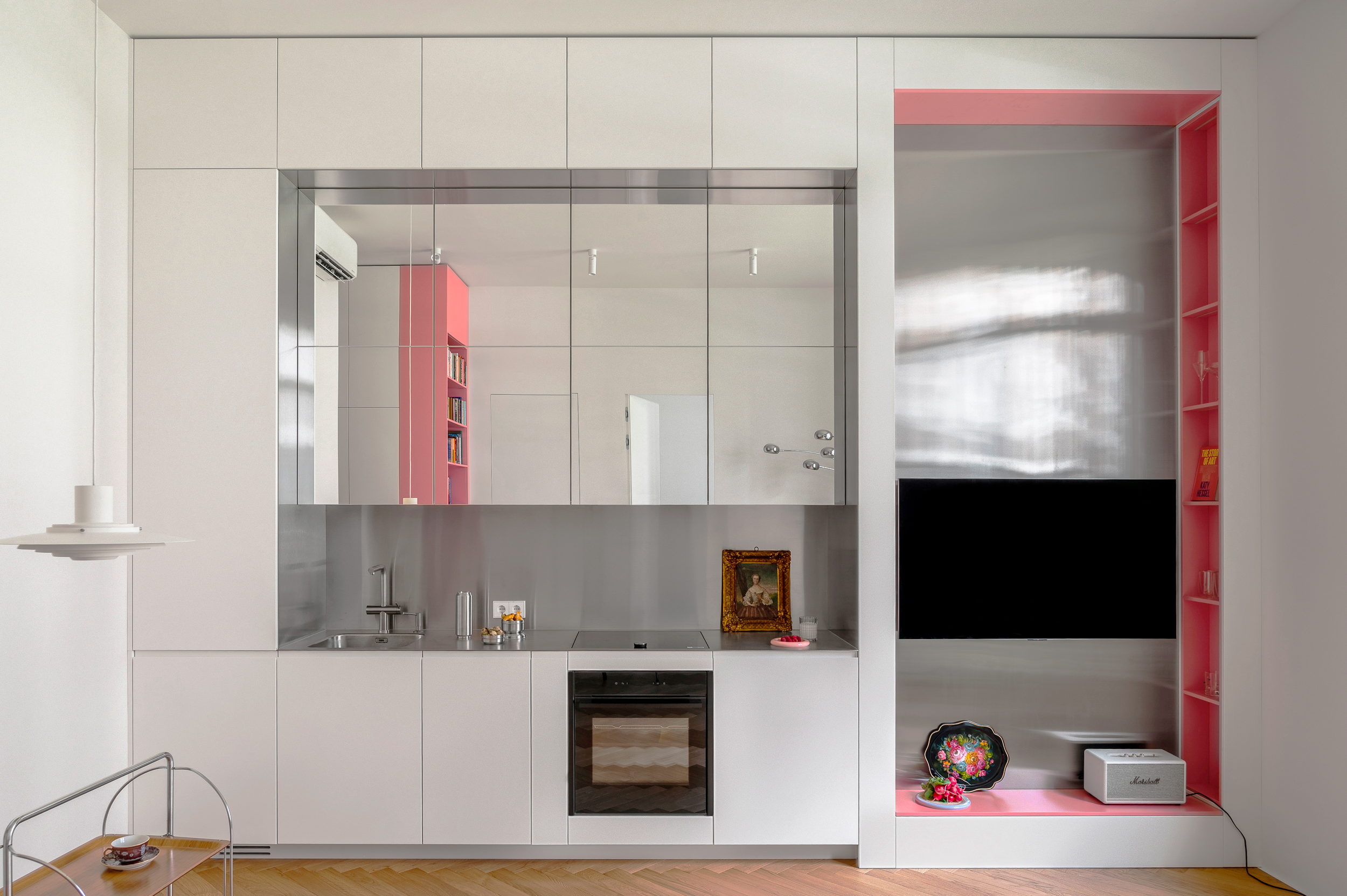 Wide view of the kitchen with white cabinets and pink shelving