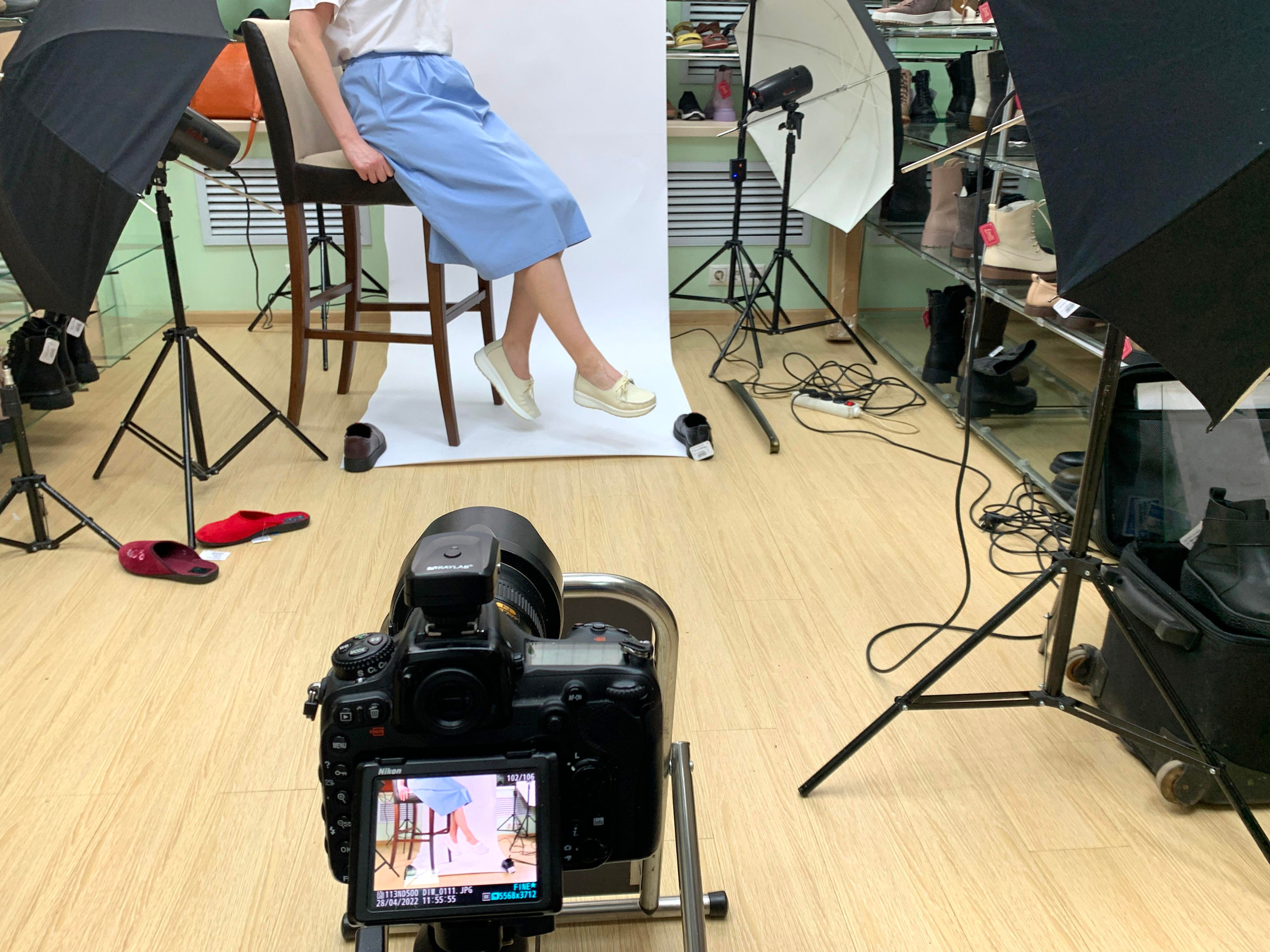 Процесс фотосъёмки обуви на ногах в офисе