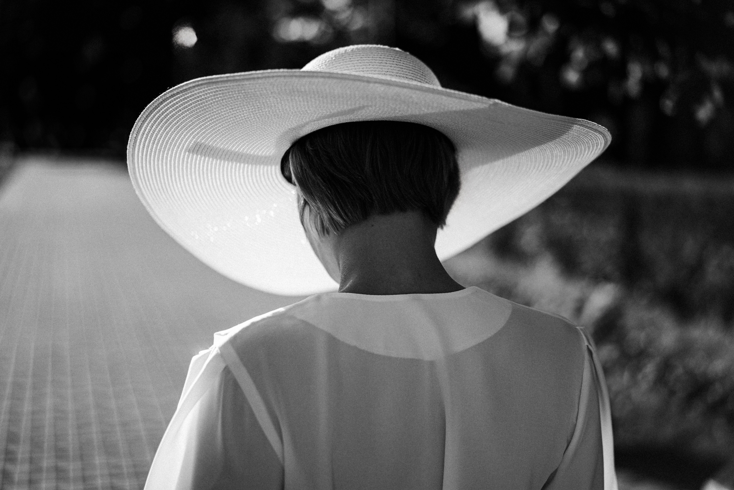 Девушка в белой шляпе смотрит вниз.