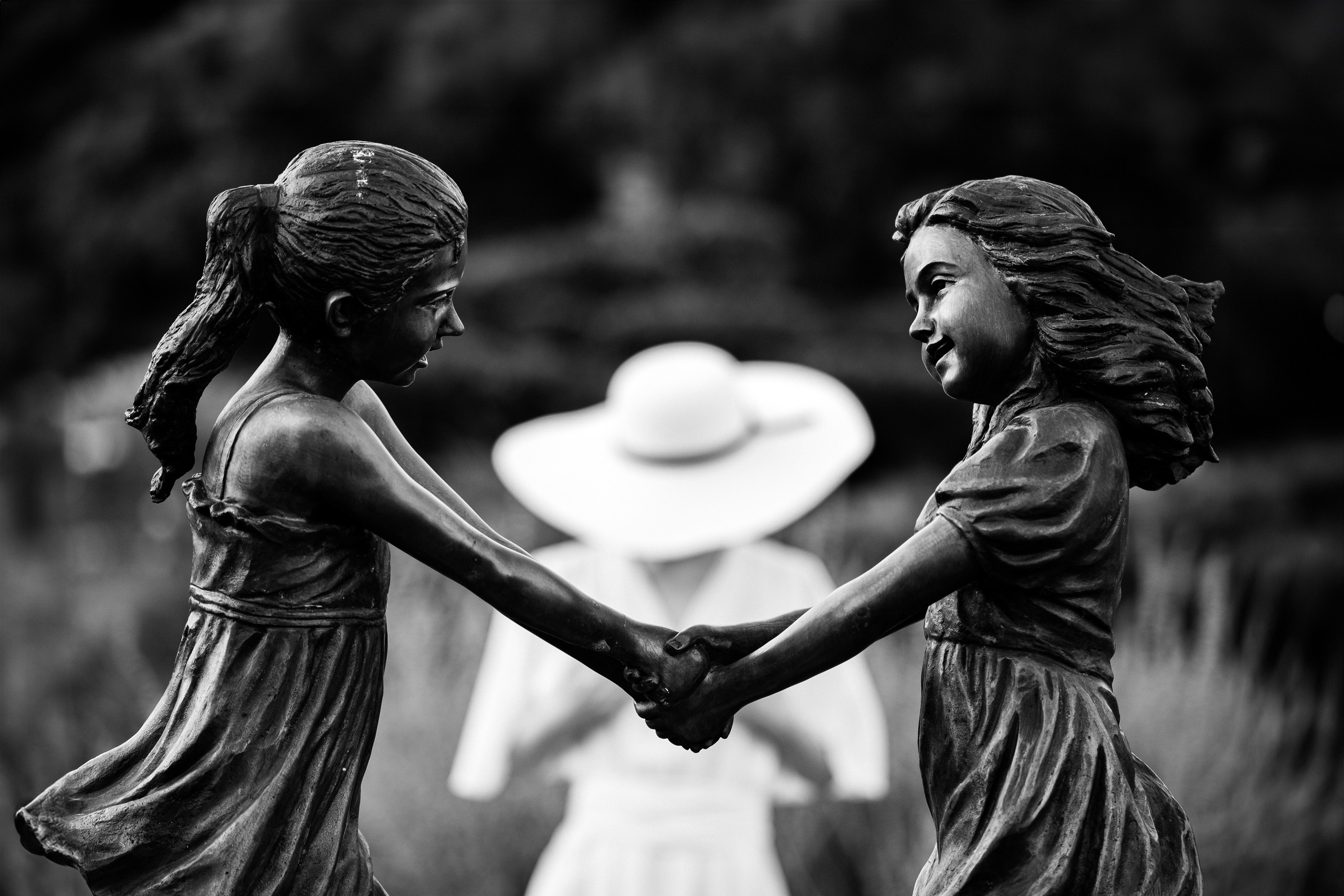 Скульптура на переднем плане. Девушка в зоне боке. 