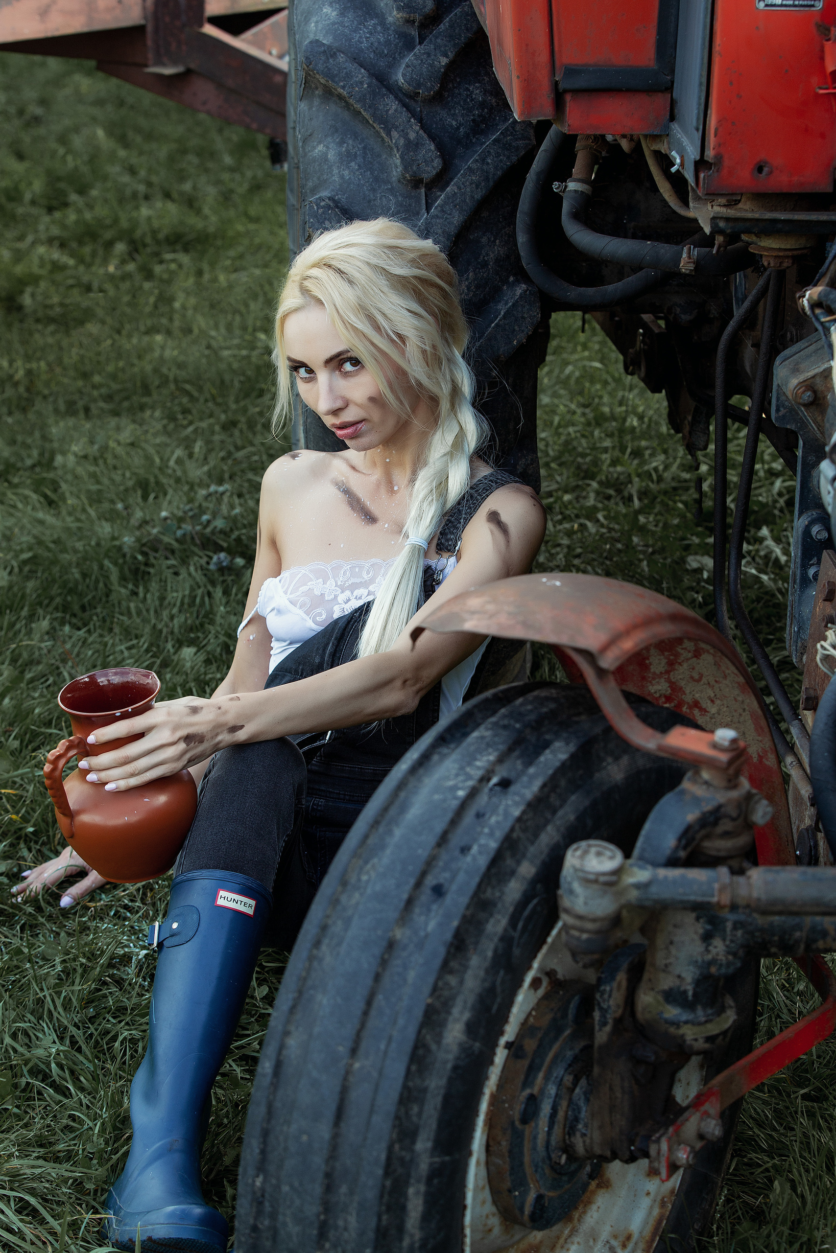 девушка с кувшином сидит у трактора