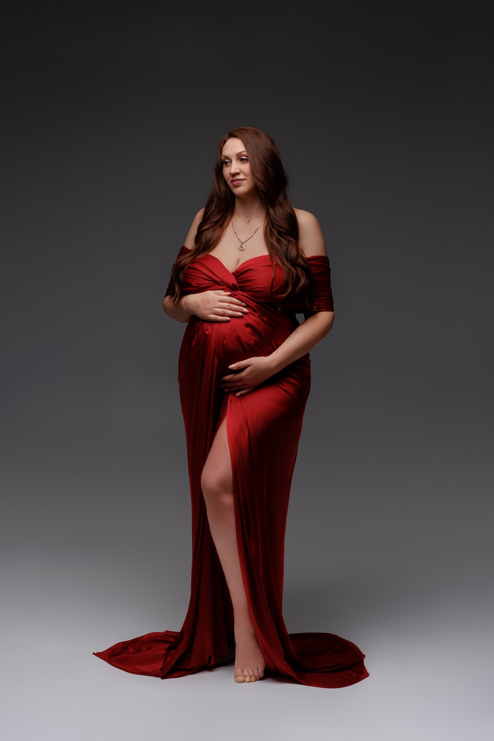 Беременная женщина в роскошном красно платье в обтяжку