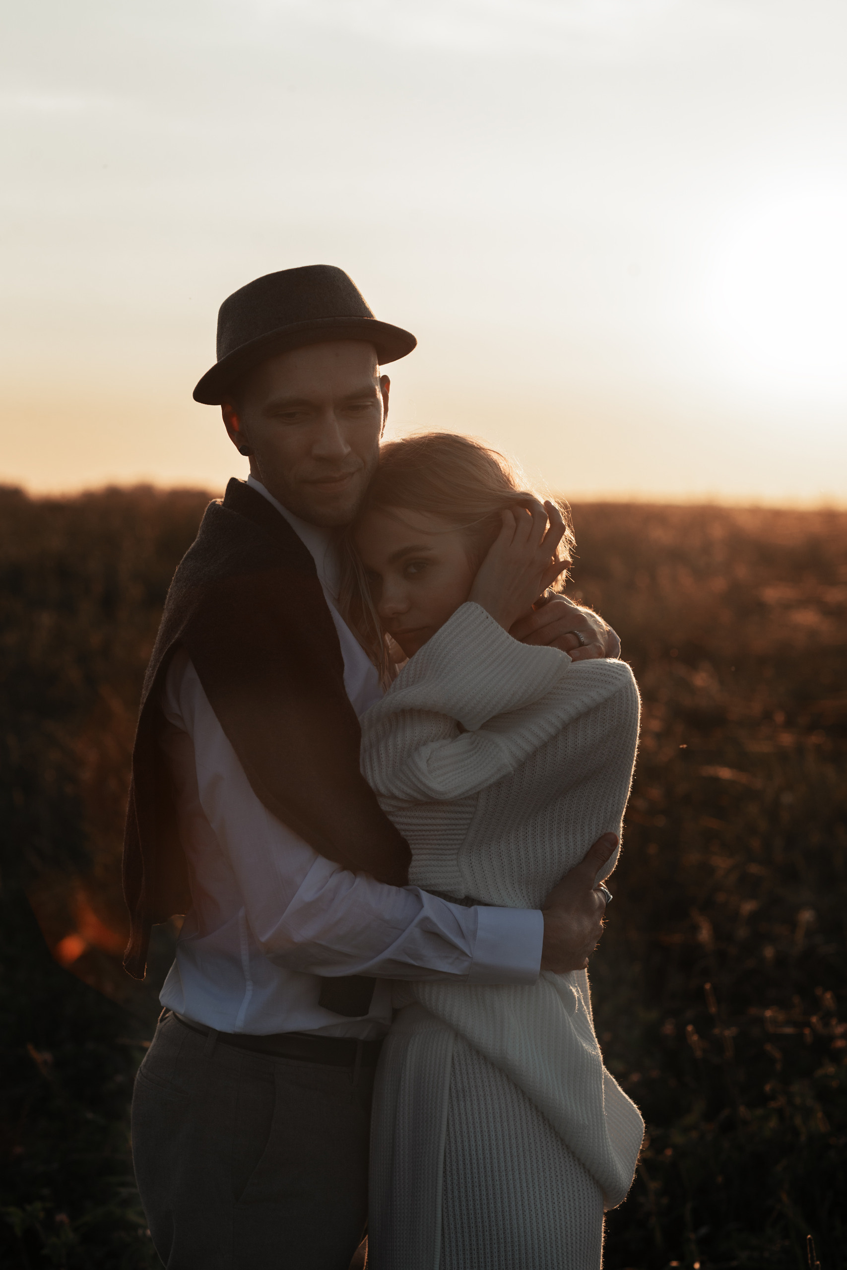 Жених очень нежно обнимает свою невесту, прижимает ее к своей груди. Она кладет слову ему на грудь.