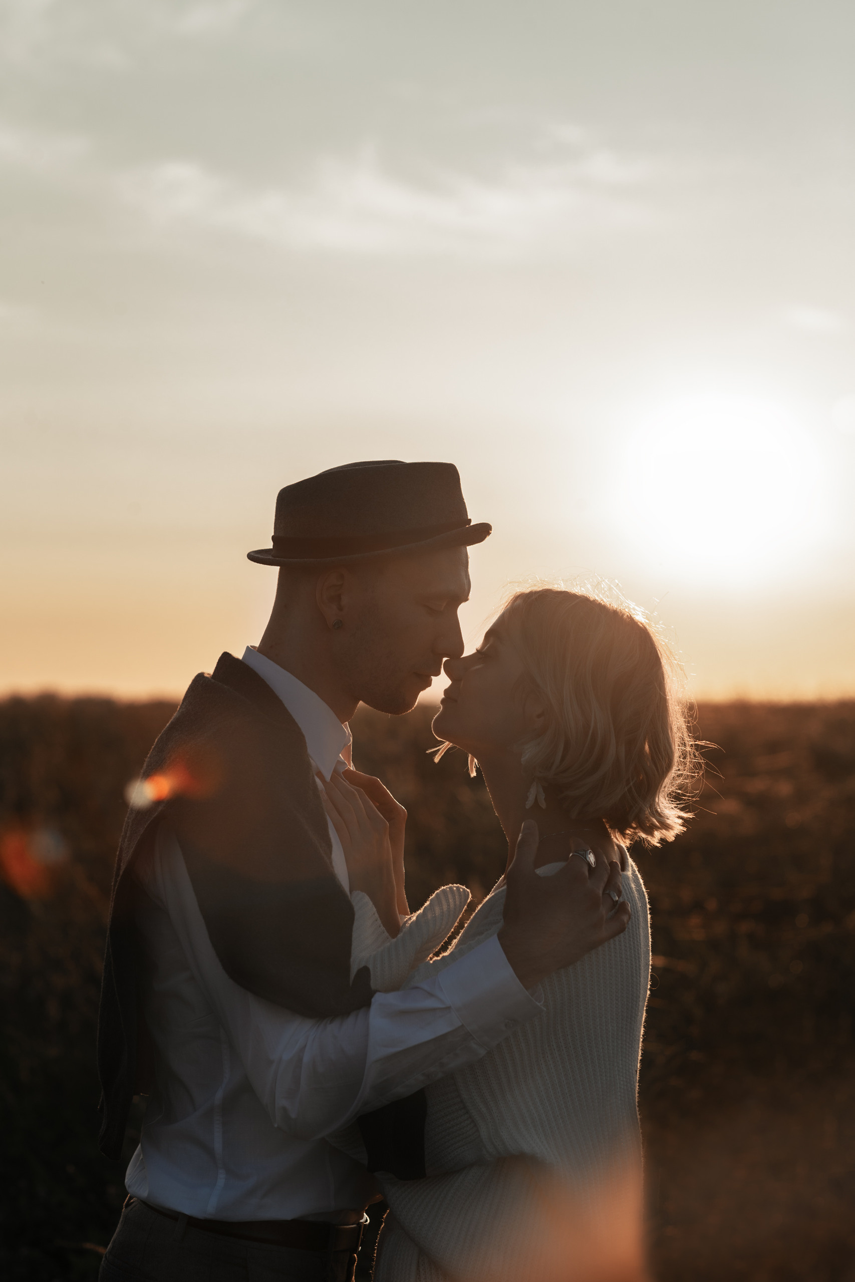 Жених и невеста смотрят друг другу в глаза, обнявшись целуются.