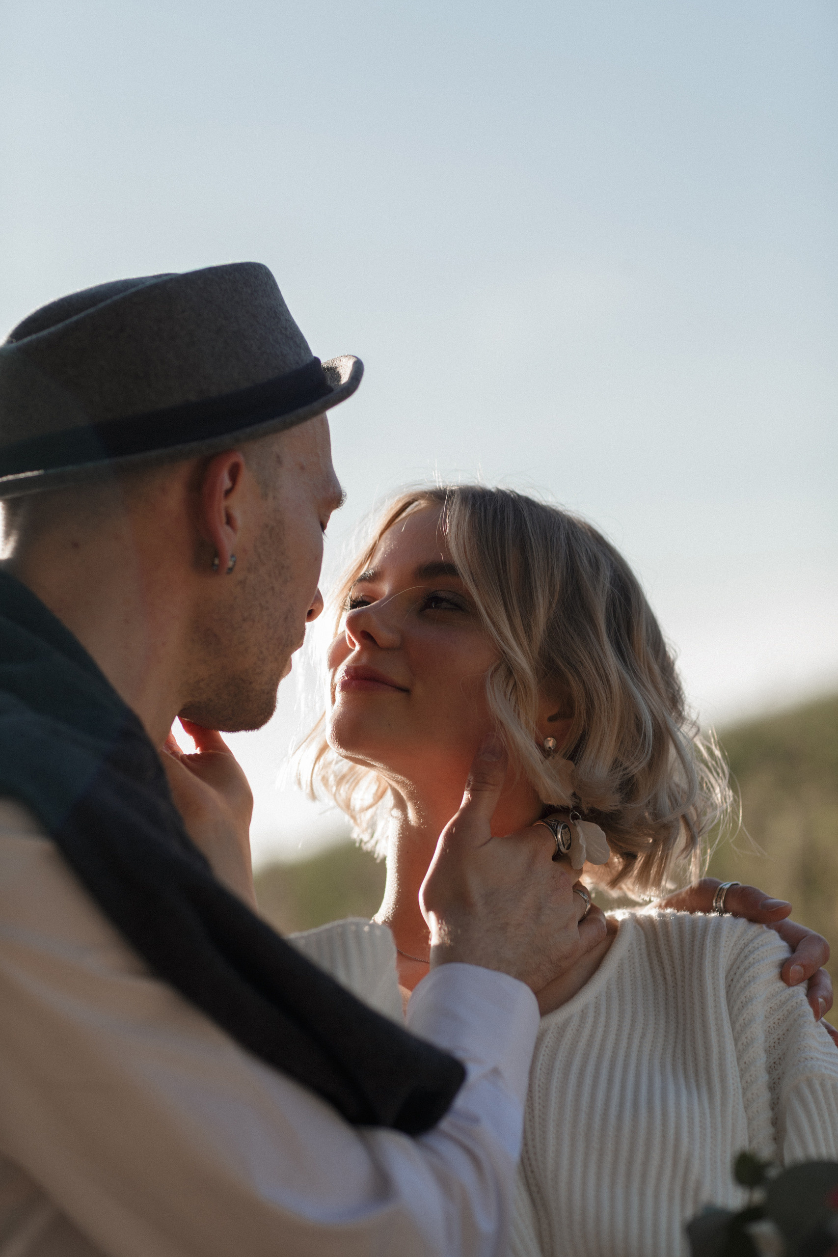 Молодожены обнявшись смотрят друг на друга и тянутся друг к другу.