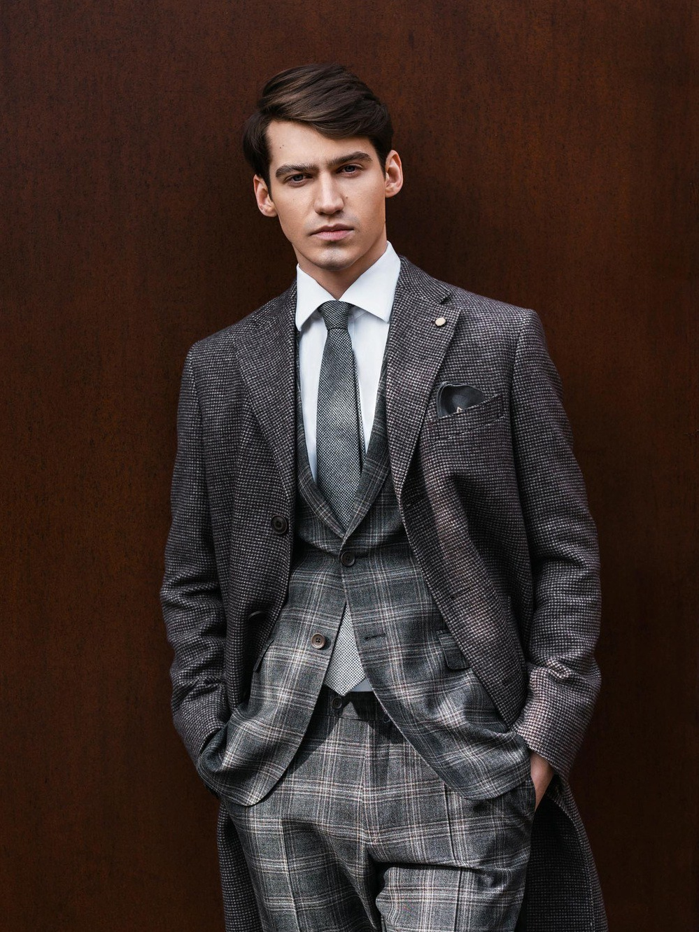 Мужчина брюнет в сером костюме и пальто